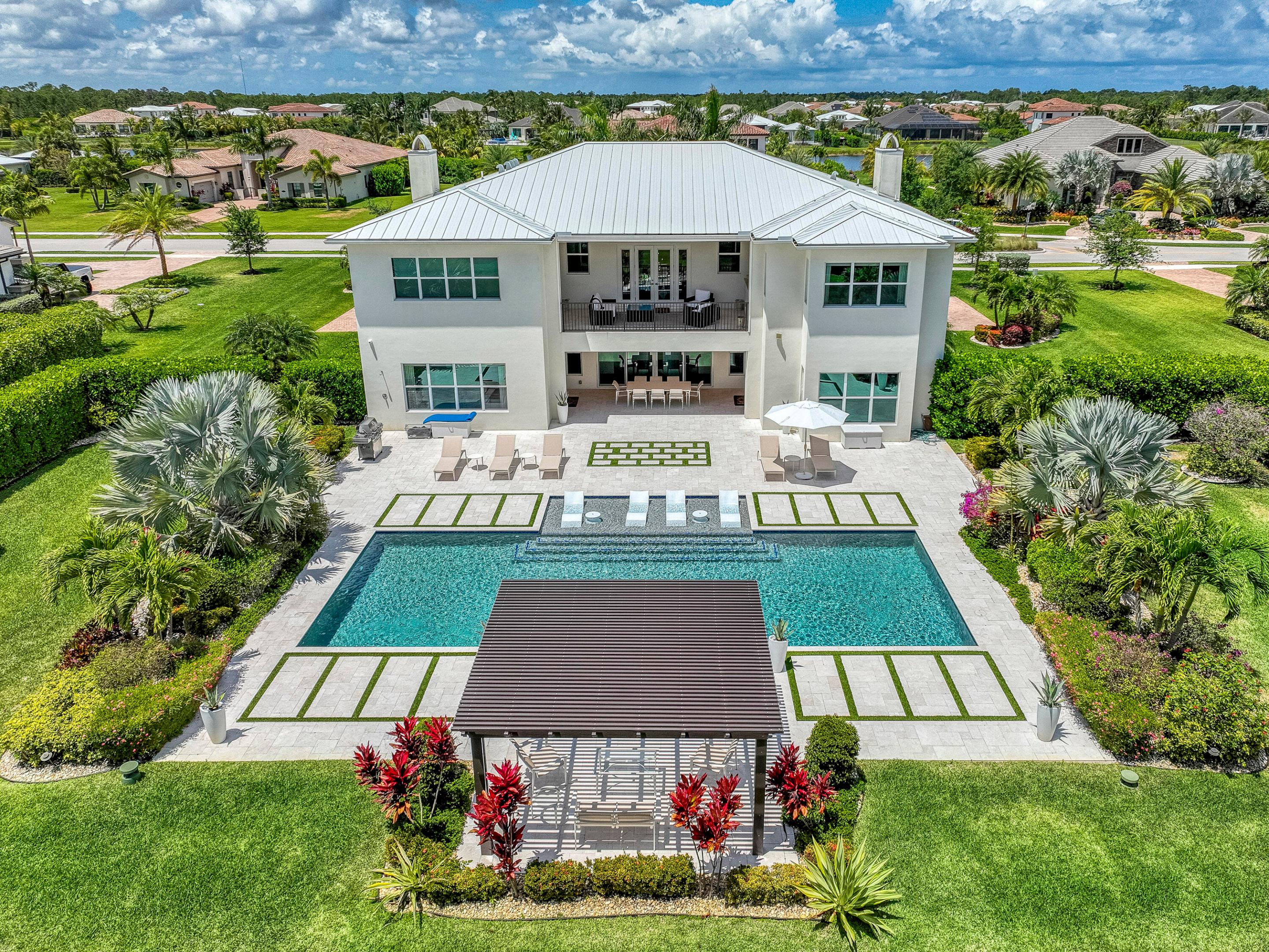 Welcome to the epitome of luxury living in the exclusive gated community of Prado Jupiter. This stunning and elegant estate offers 5645 square feet of perfection on a sprawling 1-acre lot, backing up to the North Jupiter Preserve. Boasting 6 bedrooms, 7 bathrooms, media room, club room and a 4-car garage, this home is a masterpiece of design and craftsmanship. As you enter, you're greeted by a grand entryway with double stairs, high ceilings, and abundant natural light, setting the stage for the luxurious living that awaits. The living room is adorned with custom millwork walls and designer fixtures, while the dining room features stone wall accents and modern chair railing, creating an atmosphere of refined elegance. Adjacent to the dining room, a butler's pantry leads to the impeccable open concept kitchen, showcasing quartz countertops, white modern cabinetry with glass fronts, and top-of-the-line Monogram stainless steel appliances. Restoration Hardware light fixtures illuminate the kitchen island, which offers plenty of counter seating for casual dining and entertaining. The large family room overlooks the outside entertainment area, featuring a patio with a wood inlay ceiling, electric phantom screen, speakers, turf inlay, outside shower, and natural gas hook up. A custom saltwater heated pool with a sun ledge and water and fire features, as well as a pergola-covered seating area, create the perfect outdoor oasis for relaxation and enjoyment.
Inside, the club room beckons with a bar adorned with high gloss cabinets, accent stone, and a waterfall quartz counter with pendant lighting. A large guest bedroom downstairs boasts an ensuite bathroom for added convenience. Take the elevator to the second floor, where you'll find a media room with acoustic panels and a wet bar, perfect for movie nights and entertaining. The very private owner's suite features an accent wall, sitting area, and ensuite primary bath with his and hers walk-in closets, a freestanding tub, pebble floor glass shower, and dual sinks and vanities. Four more large and bright bedrooms upstairs, all with ensuite bathrooms, provide ample space for family and guests. A laundry room upstairs adds convenience to daily living. Elevate your outdoor living experience with the expansive upstairs balcony, offering breathtaking panoramic views of the pristine preserve surroundings. Immerse yourself in the natural beauty that surrounds this exquisite property, where peace and serenity abound. Enhancing the front facade of this exquisite estate are 2 upgraded side-loaded garages, adding to the home's curb appeal and elegance. This thoughtful design enhances the visual appeal of the property. Additionally, one garage has been converted to a gym with gym mats and an additional laundry area, providing the ultimate in convenience and functionality. Home also comes equipped with an upgraded Sound system and Camera System.
Prado Jupiter, is an ideal location just 3 miles from Indiantown Road and I-95, providing easy access to major thoroughfares and nearby attractions. Want to be impressed? Come see this home today!