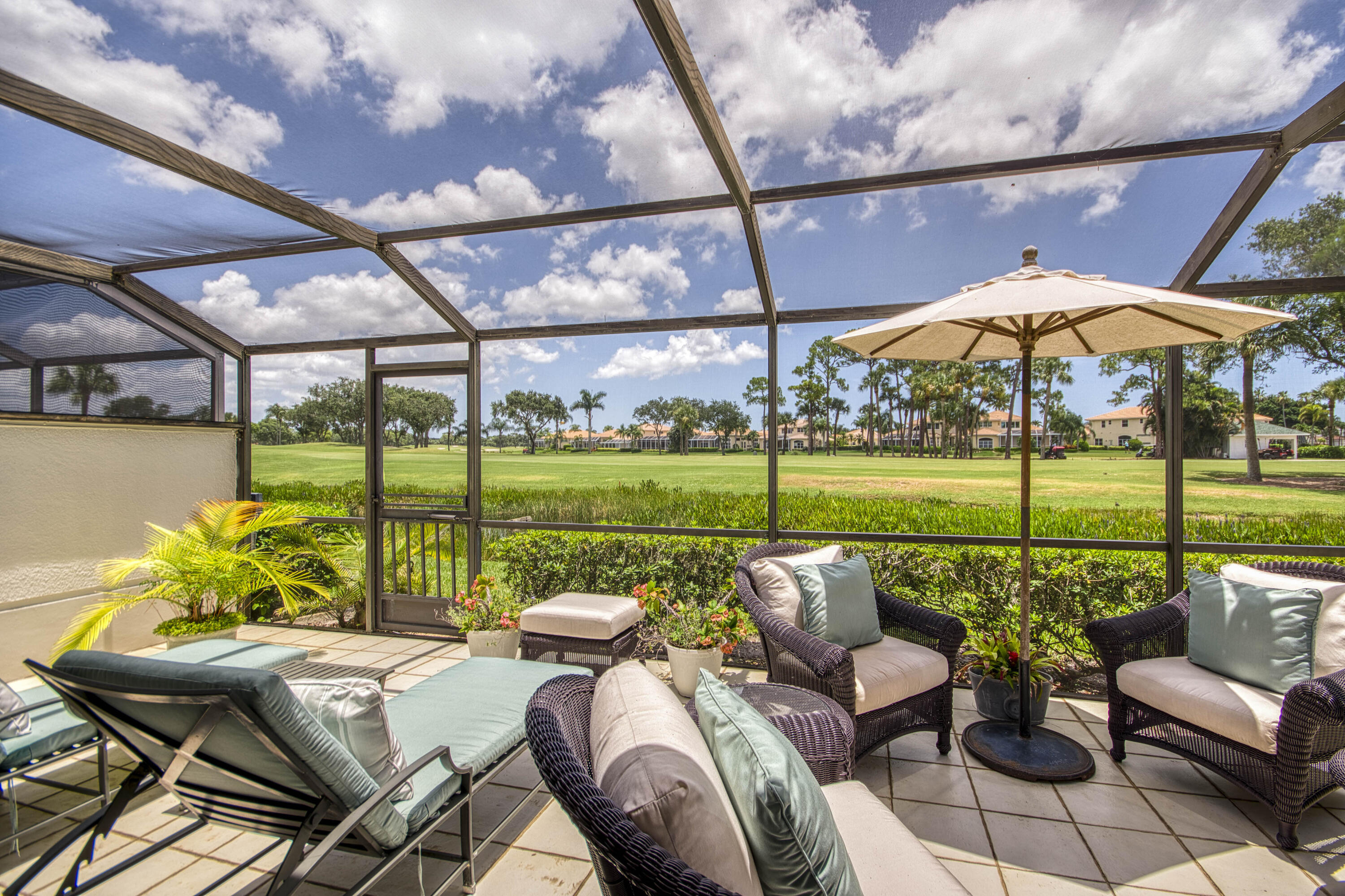 Enjoy exceptional golf course living with sweeping views of the Championship Course at PGA National, home of the Cognizant Classic on the PGA TOUR. This light-filled 3-bedroom home offers a spacious primary suite with custom closet built-ins, guest bedroom with en-suite bath, and a versatile third bedroom ideal as a den or office. Features include a bright kitchen with stainless steel appliances, open dining area, and expansive screened patio with multiple spaces for dining, lounging, and entertaining. A private courtyard entry surrounded by lush tropical landscaping completes this inviting South Florida retreat.