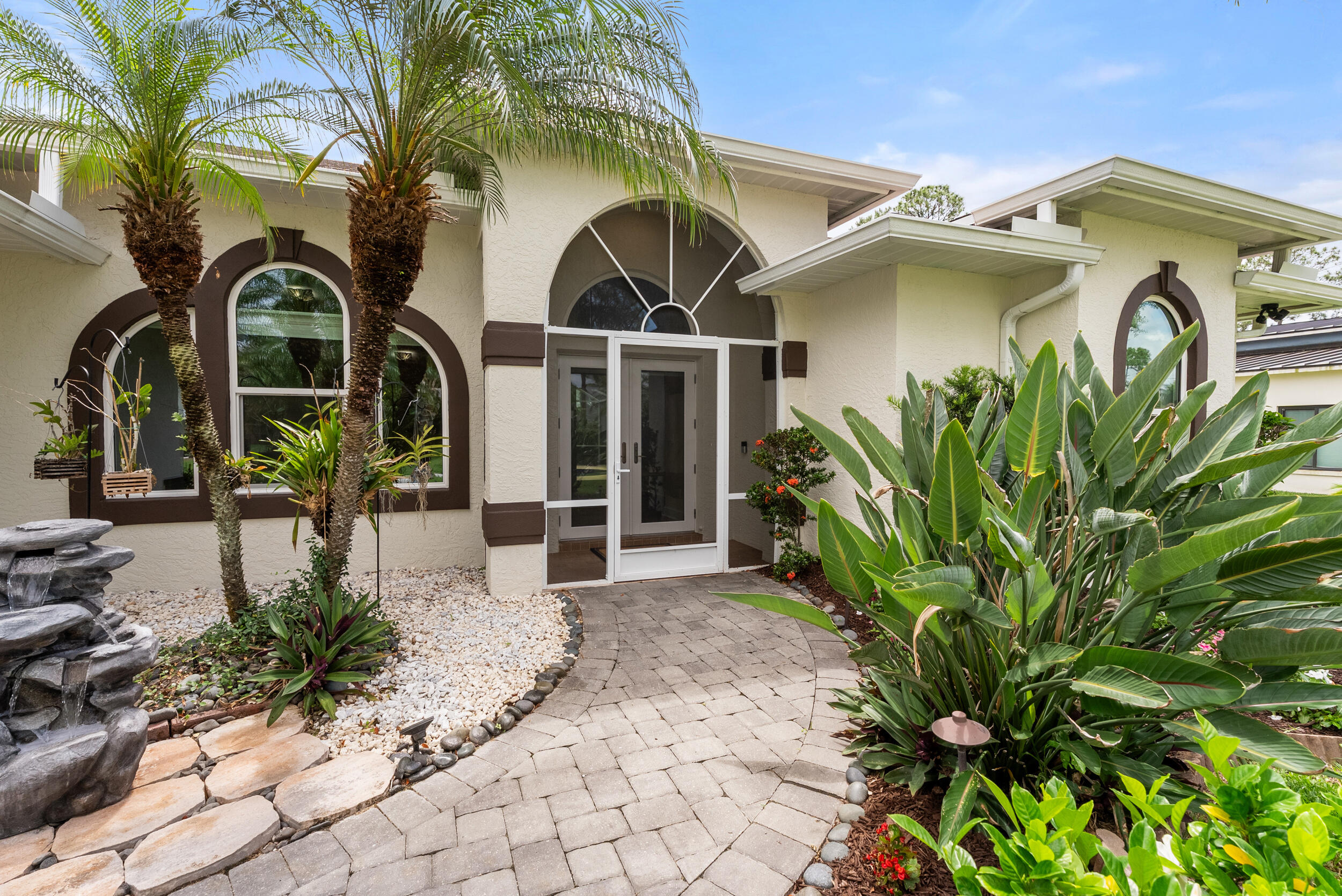 Turn-key pool home loaded with upgrades in a highly desirable non-HOA neighborhood on a quiet, beautifully maintained street. This CBS home features a newer roof, all impact windows and doors, remodeled kitchen and bathrooms, split-bedroom floorplan, and a finished garage with mini split AC. The private backyard oasis is designed for Florida living with a resurfaced, solar-heated pool, new screen enclosure, covered patio, lush landscaping, and exceptional curb appeal. Additional upgrades include a newer AC, new water heater, updated electrical panel, whole-house gutters, irrigation on private well, screened front porch and garage, and brand-new appliances.  Conveniently located near Tradition, I-95, shopping, dining, and everyday conveniences, this move-in-ready home offers the perfect blend of comfort, style, privacy, and location.