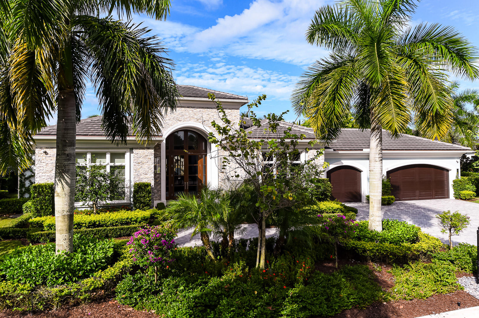 Stunning contemporary 4BR/5.1BA home located in the beautiful Old Palm Golf Club. Built in 2016 by Courchene Development, this gorgeous home features library with built-ins, formal dining room, and gourmet chef's eat-in kitchen. Grand foyer opens to formal living room with high ceilings, wet-bar, and built-in wine cellar. Gracious master suite with private entrance to the pool. Master bath features dual vanities, tub with serene waterfall backdrop, and private outdoor loggia with shower. Seamless indoor/outdoor transition with formal living room leading to screened in loggia with summer kitchen and built-in grill. Beautifully manicured grounds surround large pool and spa. Additional highlights include stunning details and flooring throughout, 3-car garage, impact doors and windows, and full house generator.