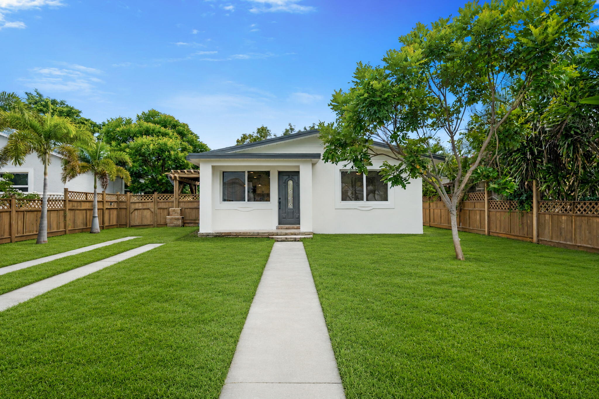 Welcome to 715 High St in West Palm Beach, a beautifully renovated home offering modern updates, a functional layout, and a spacious fenced yard with excellent outdoor potential. This property has been thoughtfully redone with brand-new impact windows, new vinyl flooring, a brand-new kitchen with soft-close cabinetry, and new stainless steel Samsung appliances. The home also features brand-new bathrooms with updated showers, recessed lighting, a serviced A/C system, and a 2024 roof, giving buyers peace of mind for years to come.  Inside, the bright open living area flows seamlessly into the kitchen, creating a clean and inviting space perfect for everyday living or entertaining. Two sets of French doors provide access to both the backyard and side yard, where you'll find a (CONT..) covered pergola area ideal for relaxing, dining, or creating a private outdoor lounge. The generous backyard is fully fenced and features a beautiful mango tree, a garden path, and a dedicated patio/square area that would be perfect for a hot tub, fire pit, seating arrangement, or future outdoor retreat. The rear alley access includes a sliding gate that can be connected to a remote system, making it ideal for secure gated parking inside the backyard. Conveniently located near Belvedere Elementary, Belvedere Rd, Dixie Hwy shops and restaurants, I-95, Palm Beach International Airport, Downtown West Palm Beach, beaches, and Palm Beach Island, this home offers a great combination of updated living, outdoor space, and central West Palm Beach convenience.   All information pertaining to the property is deemed reliable, but not guaranteed. Information to be verified by the Buyer. Be advised that cameras may exist recording audio and video inside/outside the property, such as ring doorbells. Photos are digitally enhanced and could be altered, please verify.