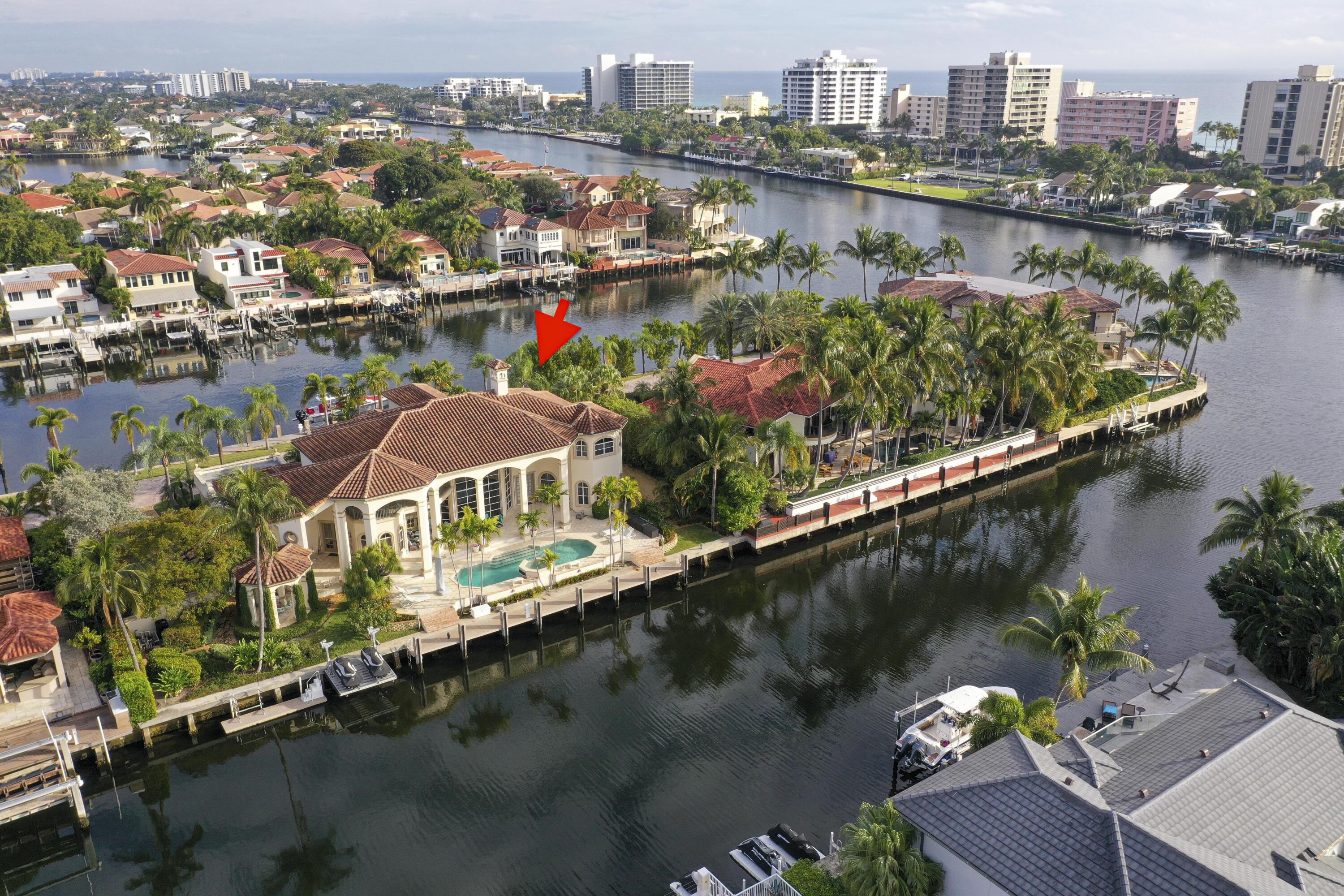 Beautiful Custom Built home located on a rare ''Double Waterfront'' gated street with a total of 300ft of deepwater. (150ft front and 150 ft back) Features lovely architectural details w/ soaring ceilings w/ wall of glass to bring in beautiful light and views of the water from almost every room. Custom built-in library, Den, coral fireplace, kitchen w/ granite, Wolf & Sub-zero appliances, wine bar, sunny breakfast room, Extensive outdoor living w/80ft covered patio, Newer Roof, 2 covered balconies, dining gazebo, summer kitchen, heated pool and spa, Lush landscaping, stone columns, old Chicago Brick drive and walkways, mosaics, and etched glass create a timeless charm.  2 new docks in front and back, new boat lift, jet ski lift and floating dock for kayaks and paddleboards. A true paradis