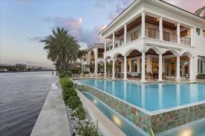 Meticulously designed, this Palm Beach-inspired Estate located on a Direct Intracoastal Point Lot with 272’ of waterfrontage is a yachtsman’s paradise and offers resort living at it’s best.  This stately residence comprises a total 12,724 +- square feet with 5 bedrooms, 6 full and 2 half baths.  From the majestic mahogany double door entry, myriad special features include the exceptional millwork, impact-glass windows and exterior doors, energy-efficient multi-zone heating/cooling with four new units and hydraulic elevator.  Radiating off the foyer, the bright window-walled living spaces flow room to room and from inside to the outdoors.  This “smart house” is equipped with a Lutron system and one of many recent updates includes a Crestron system for surround-sound.****SEE MORE**** Resort-style luxury living is expressed with fresh, elegant ease in this Palm Beach-inspired masterpiece surrounded by spellbinding waterway views on a prized Intracoastal point in Tropic Isle, a beautiful Delray Beach community known as a yachter's haven.  Capitalizing on the serene splendor of 272± feet of sprawling waterfront, this stately five-bedroom residence was brilliantly designed by noted architects Garcia Brenner Stromberg and custom built to exacting standards by A.M. Nicolli Construction.  The recent redesign of the grounds by KWD Landscape Architecture enhances the cohesive sensibility of the equally exquisite indoor and outdoor living spaces.  Other recent updates include smart-house electronics that make all systems function with high-tech ease in this impressive but comfortably livable estate home.

Inside the bright open foyer, the waterfront view takes center stage through the living room's stunning arched window wall.  Deftly planned for entertaining, all of the main living spaces radiate off the central gallery and open to the grand waterfront loggia by the dramatic infinity pool right on the point, with artistic lighting adding an atmospheric effect for night-time gatherings.  More than half of the second floor is devoted to the multi-room master suite, an ultra-luxurious sanctuary looking out over the sweeping waterways.  Complete with yacht dockage, this flawless Intracoastal point paradise is one of the finest estates of Tropic Isle.

Location
Evergreen Drive, Delray Beach, Florida.  Tropic Isle is desirable yachting community fronting the Intracoastal Waterway, a yacht harbor, and deep-draft canals.  Minutes from the beach, this tranquil neighborhood is just a couple miles south of famous Atlantic Avenue's vibrant array of bistros and boutiques in downtown Delray Beach.

Property
This spectacular Intracoastal point estate commands panoramic waterway views from 272± feet of shoreline which includes 144± feet on the side canal providing deep-draft dockage with a 15,000± pound lift.  A beautifully landscaped motor court approaches the formal entry and four-bay garage also with convenient dockside access for sports equipment.  Tropical foliage adorns the waterfront's magnificent outdoor entertainment space featuring a loggia centered on a night-lit quatrefoil fountain.  The sleek infinity pool and spa seem to spill into the waterway.  A summer kitchen serves the side patio.

Residence
Exceptional design and workmanship hallmark this understatedly elegant residence in a grand total of 12,724± square feet with five bedrooms, six full and two half baths, two laundry rooms, and an elevator to all three levels.  Fine architectural millwork, Jerusalem stone and hardwood floors, and impact-rated windows and exterior doors are featured finishes.  Myriad amenities include a sophisticated security system, energy-efficient multi-zone climate-control systems, a whole house generator, a Crestron surround-sound system, Lutron lighting, and remote-controlled window treatments.  

First Floor:  Inside the stately mahogany entry, the two-story foyer flows across the columned gallery into the bright double-height living room dominated by an immense arched window wall opening to the loggia and waterfront view.  French doors also lead to the loggia from the handsomely paneled club/game room, set off by a coffered ceiling, complete with a built-in wet bar and tropical aquarium.  Also richly paneled, the library is fitted with elaborate custom built-ins below the intricate tray ceiling with gilded finish.  A powder room adjoins.  Flowing off the gallery and living room, the elegantly molded dining room opens its doors to the waterfront loggia and has a convenient butler's pantry/wet bar and powder room adjacent. A masterful mix of style and functionality, the chef's kitchen includes custom cabinetry, granite counters, a professional-style eight-burner Viking gas range with double ovens, a Miele steam oven and coffee system, Sub-Zero refrigerator and freezer, and dual Bosch dishwashers.  Separated by a bar counter, the light-flooded family/breakfast room with furniture-style media center is wrapped with window walls opening to the loggia and waterfront view.  Leading to the waterside patio, the VIP guest suite has a luxurious bath that doubles as the cabana bath.  Another bedroom suite is in a separate wing.

Second Floor:  Encompassed in an expansive private wing, the exquisite master suite is filled with breathtaking panoramic waterway views, and opens to waterfront balconies off both the bedroom and sitting room/office lined with custom built-ins including an onyx morning bar.  Water views also backdrop the suite's two luxe marble baths, one with a jetted tub and glass-enclosed shower, the other with a steam shower.  Two large custom-fitted walk-in closets complete the master quarters.  Across the bridge gallery, two more bedrooms with private baths include another waterfront suite with its own sitting area and balcony.

Third Floor:  Accessed by stairs or elevator, the observation/fitness room opens to a dramatic waterfront balcony looking up and down the Intracoastal.

DISCLAIMER: The information provided herein including but not limited to measurements, square footages, lot sizes, calculations and statistics have been obtained and conveyed from third parties such as the applicable Multiple Listing Service, public records as well as other sources. All information including that produced by the Sellers or Listing Company are subject to errors, omissions or changes without notice and should be independently verified by any prospect for the purchase of a Property.  The Sellers and Listing Company expressly disclaim any warranty or representation regarding all enclosed information.  Prospects' use of any information herein is acknowledgement of this disclaimer and that Prospects shall perform their own due diligence.  Prospects shall not rely on this information when entering into a contract for sale and purchase.  Some affiliations may not be applicable to certain geographic areas. If your property is currently listed, please do not consider this a solicitation.   In the event a Buyer defaults, no commission will be paid to either Broker on the Deposits retained by the Seller. "No Commissions Paid until Title Passes."    Buyer pays title insurance, Florida documentary stamps, and all other closing costs for New Construction and land use. Copyright 2016 Listing Company.  All Rights Reserved.