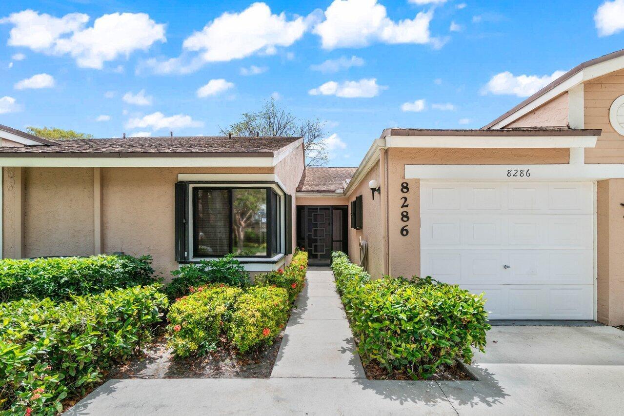 Lovely 2 beds/2 bath villa in beautiful gated 55+ Whisper Walk! NEW ROOF 2026! Accordion shutters! Renovated kitchen w/granite countertops, elegant laminate flooring, updated bathrooms, desirable split-bedroom floor plan. Relax in the  air conditioned Florida room enjoying tranquil lake views! This home also offers a one car garage w/ two additional cars in the driveway. Whisper Walk is beautifully maintained with lush landscaping & scenic lakes. Amenities include internet, cable, water, exterior insurance, 6 pickleball courts, 7 tennis courts (can be lit for night time playing), nice clubhouse, large pool & spa, sauna, fitness center, and more. Whisper Walk is centrally situated in the heart of gorgeous Boca Raton, just minutes from premier shopping, dining, beaches and major airports!