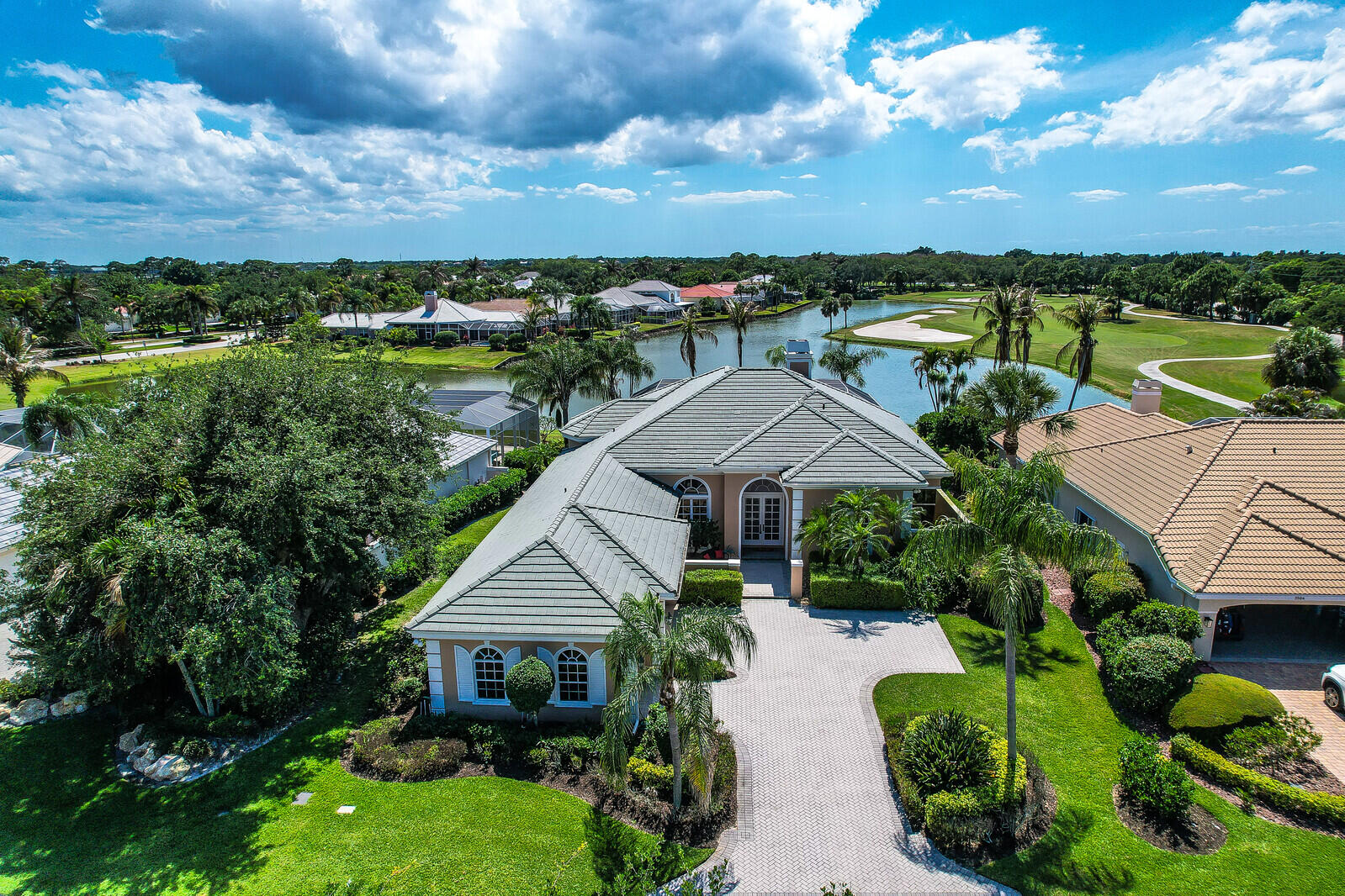 Nestled in the highly sought-after Ballantrae gated golf course community, this former builder's model offers an exceptional opportunity to own a well-built home in the heart of it all. Perfectly positioned with gorgeous, expansive water & golf course views, this one-owner residence has been lovingly cared for & gently lived in. Featuring 3 spacious bedrooms, 3.5 baths, & a versatile den/office, the home boasts a thoughtfully designed open floor plan with soaring ceilings, large windows & an abundance of natural light throughout. The main living areas showcase a spacious open concept, while a charming wood-burning fireplace adds warmth & character. Designed for both comfort & entertaining, the home includes a private pool & spa overlooking the serene landscape, view & breathtaking sunsets. The generous room sizes and solid construction provide "great bones," offering the perfect canvas for modern updates to suit your style.  Additional highlights include a 3-car garage, two A/C systems one replaced in 2023 and the other in 2018, pool pump is new, water heater 2025, wine cooler is brand-new, stainless-steel appliances were replaced 1 year ago and the roof was replaced in 2012, reflecting consistent and attentive maintenance.  Ideally located just minutes from shopping, dining, and beautiful beaches, this home combines tranquility with convenience—truly central to everything. A rare opportunity to own in a prime location with incredible potential.