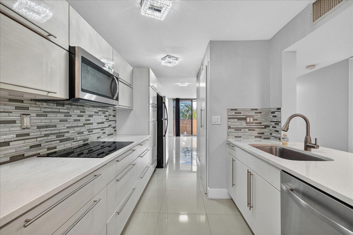 Tucked inside an intimate two-building community in the heart of Plantation, this updated 2BR/2BA condo is the kind of home that just makes sense. Come into a space that's been thoughtfully refreshed — a beautifully renovated white kitchen featuring quartzite counters, contemporary cabinetry, large electric cooktop, and stainless steel appliances and skillfully conceals a full-size washer and dryer behind cabinet doors. Large-scale tile flooring runs throughout, giving every room a clean, modern look, and the updated bathrooms makes the everyday feel a little more elevated. The layout is generous for a condo — two full bedrooms, two full baths, and walk-in closets that actually hold your life.  A bright breakfast nook and tankless water heater round out a home that's move-in ready. The building itself is in the middle of a meaningful refresh — new roof already completed, and elevator modernization and exterior painting in progress. Outside you'll find a pool, playground, gated entry, and two assigned parking spaces.  Building has strong reserves, and well-qualified buyers may buy with as little as 5% down!! All ages welcome. Close proximity to Sawgrass Mills, Fort Lauderdale Beach, and the highways.  This condo provides exceptional value and makes Florida living a breeze.