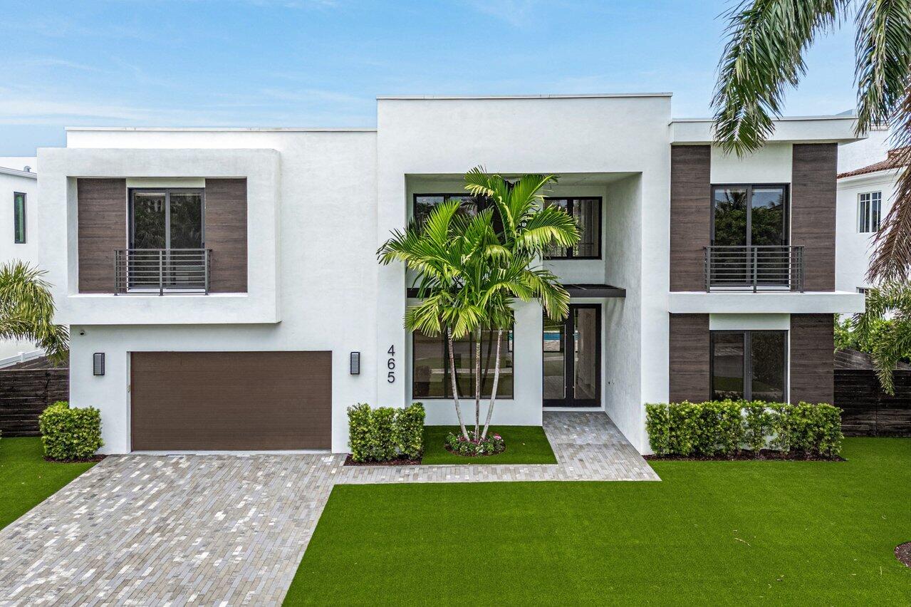 This spectacular 5 BD 5.5 BA is a turn-key, ultra-modern beauty both inside and out. Through the grand entrance, immediately notice the pour of light from both front and back windows that stretch up to the ceiling. The kitchen is a chef's dream, with two massive islands, a Sub-Zero refrigerator, a Wolf gas stove and oven, two dishwashers, two sinks and a breathtaking white-gray marble backsplash that ties together high-gloss, flip-lift upper cabinets and light wood lower cabinets. Between the two islands, large walk-in pantry, and seemingly limitless cabinet space, kitchen storage is suited for the professional home chef. Downstairs, find two large living areas, a breakfast area, a guest room with a walk-in closet and ensuite bathroom, and a dining room with an adjacent bar area. Take the dark wooden stairs with stainless steel railings to the second level to find the magnificent primary bedroom, which features a wrap-around balcony, coffered ceilings, and his-and-her closets. The captivating primary bathroom is adorned with a lavish tub, a walk-in shower, and two LED vanity mirrors. Additionally, upstairs, you can find a large laundry room, loft, and three ensuite bedrooms, all boasting walk-in closets, two of which have sliding doors with front-facing balconies. The backyard, made private by a luxe dark wooden fence, is landscaped to perfection with artificial turf, privacy shrubs, and imposing traveler's palm trees. A beautifully renovated pool and spa make for the perfect outdoor oasis suited for both relaxation and entertainment, complete with a covered patio under grand ceilings and an outdoor grill.