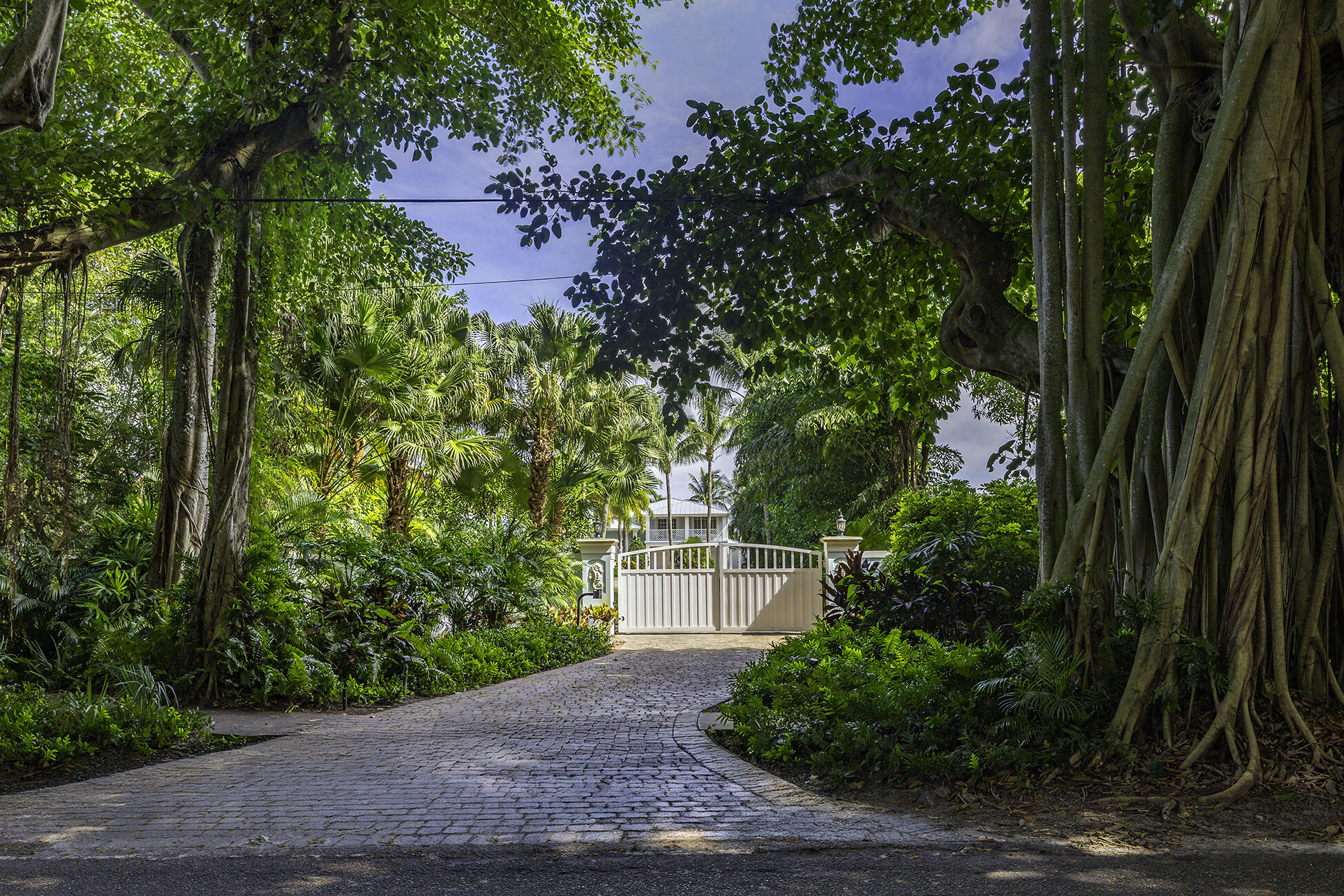 The banyan tunnel leads you to a rare trophy WATERFRONT estate, move-in ready and fully furnished. At the end of Stuart's most photographed road, your gated drive opens to nearly an acre of PRIVACY and 500' of protected shoreline with sweeping views toward the INLET and ''The Crossroads.'' Enjoy true deepwater dockage with multiple docks, two lifts, room for an 80' yacht, and quick ocean access. Reimagined in 2023/2024 with a new standing-seam metal roof, full impact glass, whole-house generator, and new garage doors. The home blends timeless Key West architecture with modern coastal design. Perfect for true boaters and entertainers, with media room, balcony suite, heated saltwater pool, tiki bar, lush landscaping, guest house, no HOA, minutes from downtown Stuart, and not in a flood zone
