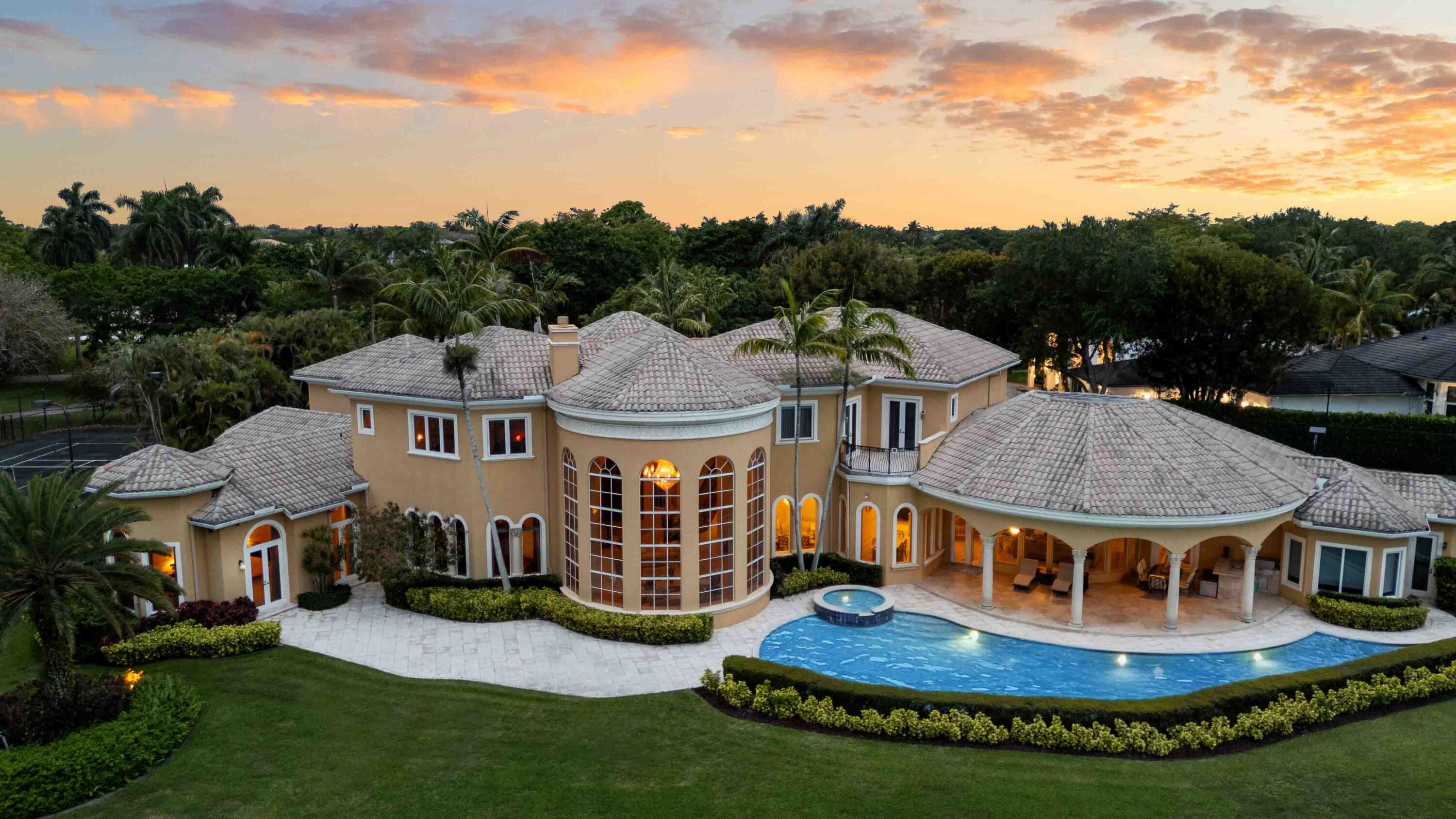 Step into a world of timeless elegance and unmatched luxury with this stunning 2-story estate in Boca Raton's exclusive Long Lake Estates. Perfectly positioned at the end of a tranquil cul-de-sac, this property offers over an acre of manicured grounds and 356 feet of picturesque lake frontage.   Spanning 9,155 sq. ft. of living space (10,901 total sq. ft.), this architectural masterpiece is a true work of art. Inside, you'll find bespoke millwork, graceful curved arches, and stately stone columns that showcase meticulous attention to detail. These striking elements are complemented by 8 bedrooms, 9.5 bathrooms, and two spacious garages with 5 bays—perfect for car enthusiasts. A grand circular driveway, framed by lush landscaping, leads to the stately double doors that open into a  breathtaking living room. Six soaring 18-ft arched windows, a 28-ft vaulted ceiling, and serene lake views create a dramatic yet inviting ambiance, complete with a cozy fireplace. Two marble staircases, accented with ornate metal balusters and cherry wood handrails, exude sophistication, while the first-floor master suite offers a private sanctuary. This expansive retreat boasts a gas fireplace, sitting area, his-and-hers vanities, walk-in closets, onyx counters, a double shower, Jacuzzi tub, and even a breakfast bar for morning indulgences.  Designed for culinary artistry, the gourmet kitchen is a chef's dream, featuring a massive center island, Sub-Zero refrigerator and freezer, Viking gas range with double oven, GE convection oven, butler's pantry, and walk-in pantry. Adjacent to the kitchen, the sunlit family room provides panoramic views of the pool, tennis court, and shimmering lake.  Additional interior highlights include a cherry wood library, a sunroom, a first-floor guest bedroom, and a separate guest house that doubles as an exercise room.  Outside, the resort-style amenities are nothing short of extraordinary. Enjoy a private tennis court, an expansive covered patio with a fully equipped summer kitchen, and a custom pool featuring a 70-ft swim lane and a relaxing umbrella lounge area.  Set within a gated community offering 24-hour manned security and roving patrols, this estate is the epitome of privacy, elegance, and luxury living.
