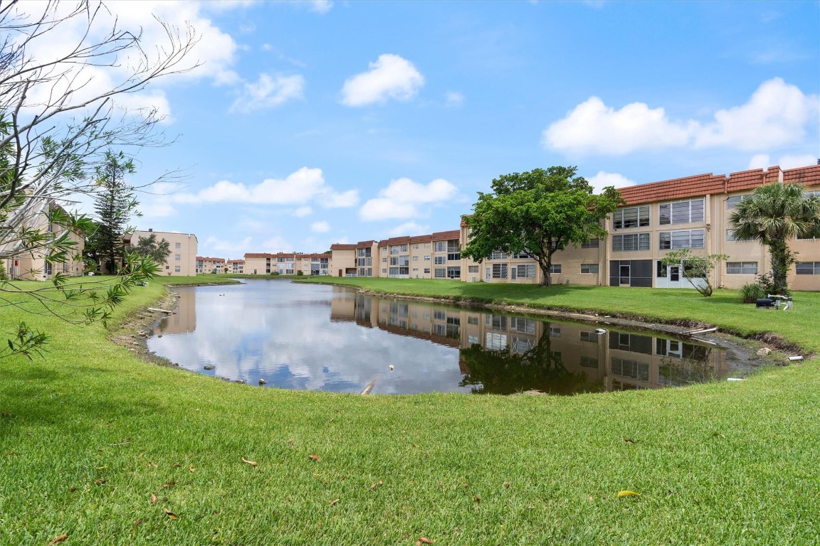 Corner 2 bedrooms/ 2 baths unit with a screened balcony overlooking the lake. Newer kitchen with stainless steel appliances ( no fridge ) and Formica countertops. Tile floors throughout. Vintage bathrooms are ready for your renovation. This active adult community offers plenty of activities and amenities for residents to enjoy including a golf course, tennis and pickleball courts, and exercise room. No leasing and no pets per association. Laundry facilities on premises. Easy access to shopping, restaurants, airport,  parks, beaches, highways, medical facilities, and entertainment.