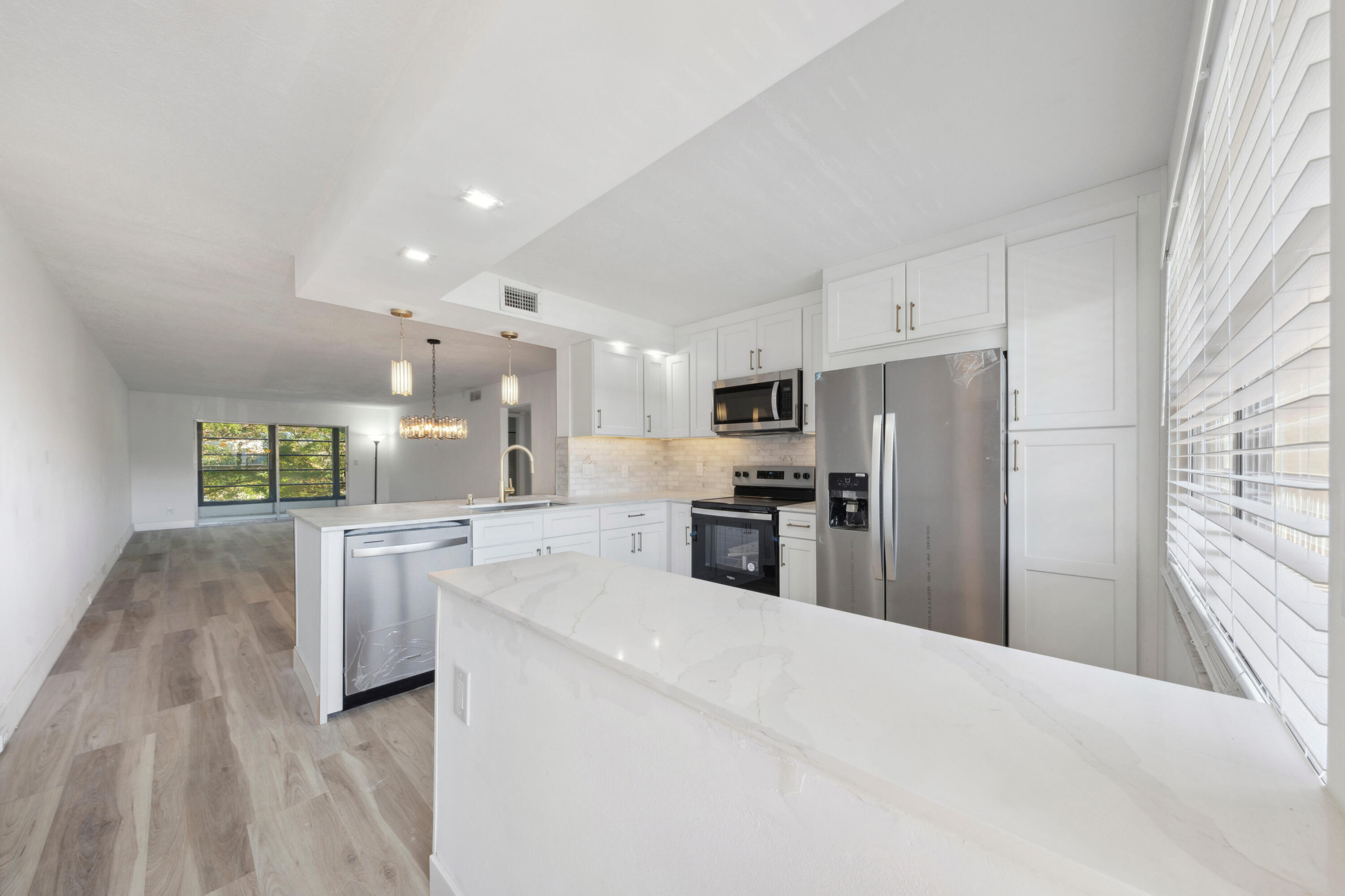 Stunning unit in Wynmoor! Overlooking scenic golf course, this spacious 2/2 has it all... renovated and redesigned from floor to ceiling. with proper permitting and code approved workmanship! Outstanding features include remodeled, open kitched w/ "New Storm Gold" Quartz countertops, solid wood cabinets w under-cabinet LED lighting; marble backsplsh & all new stainless steel appliances; luxury, high-grade vinyl plank flooring throughout; gorgeously renovated bathrooms, including redesiigned master w expanded shower and stone-floor finish; all new plumbing, fixtures & vanities; brand new A/C & water heater, all new electrical panel and wiring; upgraded light fixtures & more! Enjoy the amenties & lifestyle of Wynmoor, and peace of mind of fully renovated unit w 40-year inspection complete!