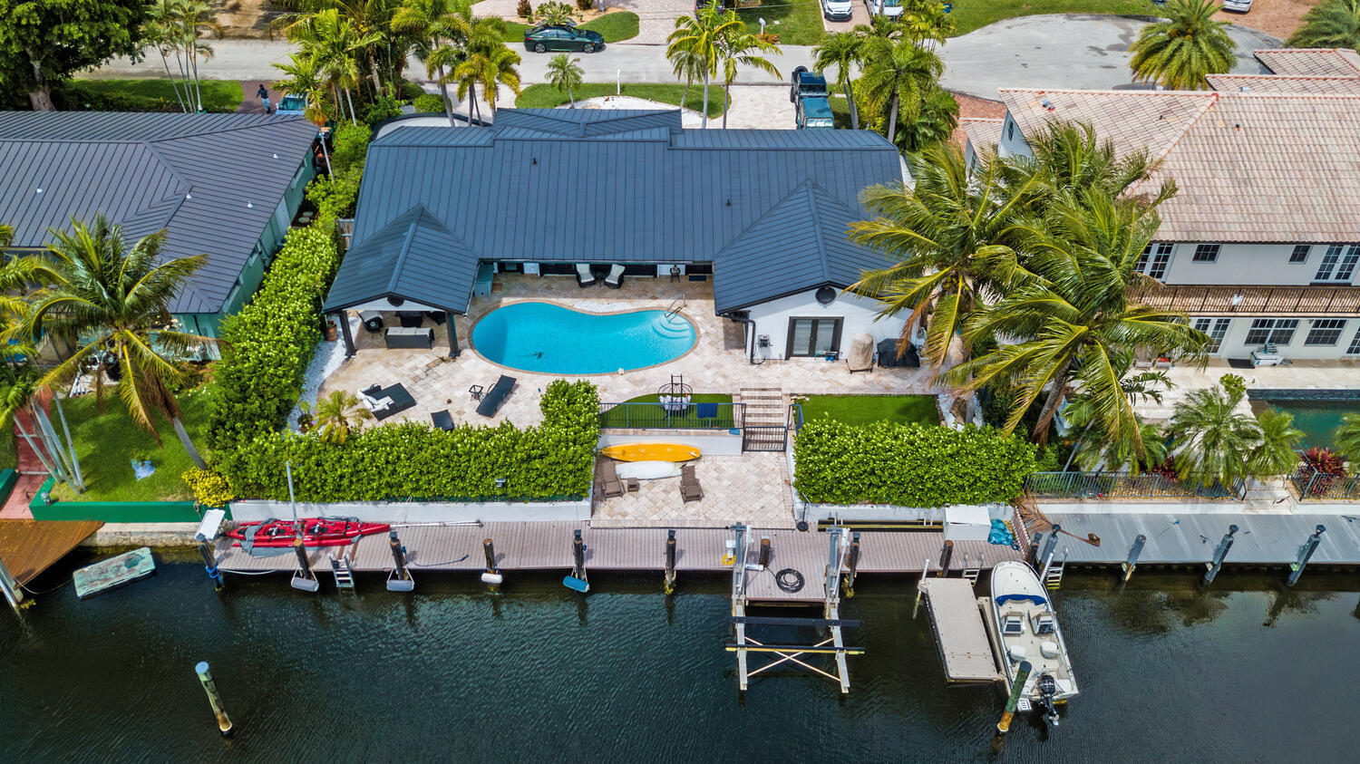 Stunning waterfront gem in Lighthouse Points Venetian Villas. This beautifully redesigned 3 bedroom 2 bath home offers an open concept layout and many custom touches. Designer island kitchen with Viking  appliances and wine cooler, sub zero refrigerator & coffee bar area. A separate dining area plus a custom built in office area and very cozy living room with vaulted ceilings and 3 sets french doors leading  to the pool area.  Newer metal roof , impact windows and  beautiful plantation shutters  throughout..Large 14x14 covered patio serves as outdoor living room overlooking the sparkling pool, 2 turf areas & nice  &   lounge area create a true sanctuary. Boaters will delight with the 100+ ft wide canal the updated  90' dock &17,000 lb boat lift. Nicely landscaped ready to go inside & out!
