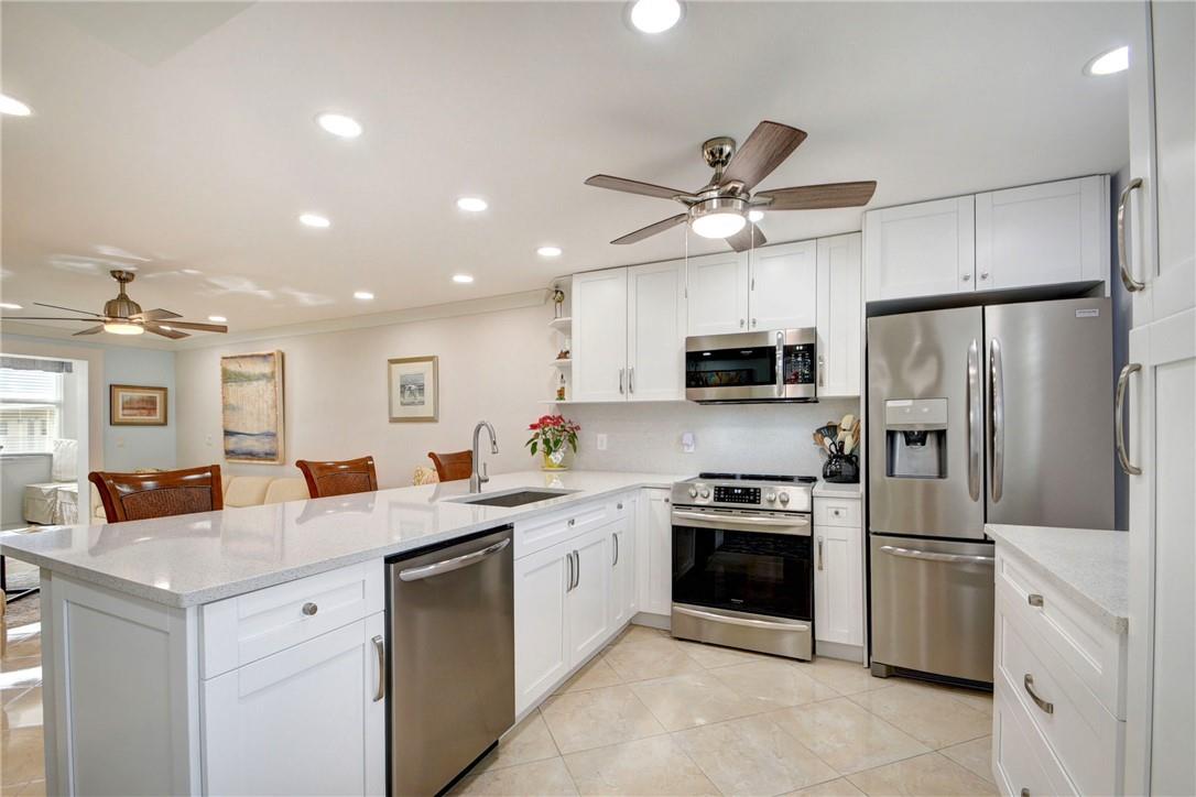Open concept beautifully re-modeled and fully-modernized fourth-floor one-bedroom! Enlarged and newly-updated open kitchen with quartz countertops, deep large sink, white shaker style all wood cabinets, and top-of-the line stainless Frigidaire appliances. Large breakfast bar with custom quartz-top rolling table to provide extra seating. Enclosed Florida room with completely re-done closet and new shelving. 5-zone dimmable recessed LED lighting. Crown molding. Popcorn ceilings removed. Smooth ceramic tile flooring with shiny finish throughout. Stain-glassed impact front door. Custom curio lighted Niche in hallway with glass shelving. All new 3-panel shaker style doors. Spa-like master bath with designer finishes and widened entrance. Impact windows throughout. Fantastic location!