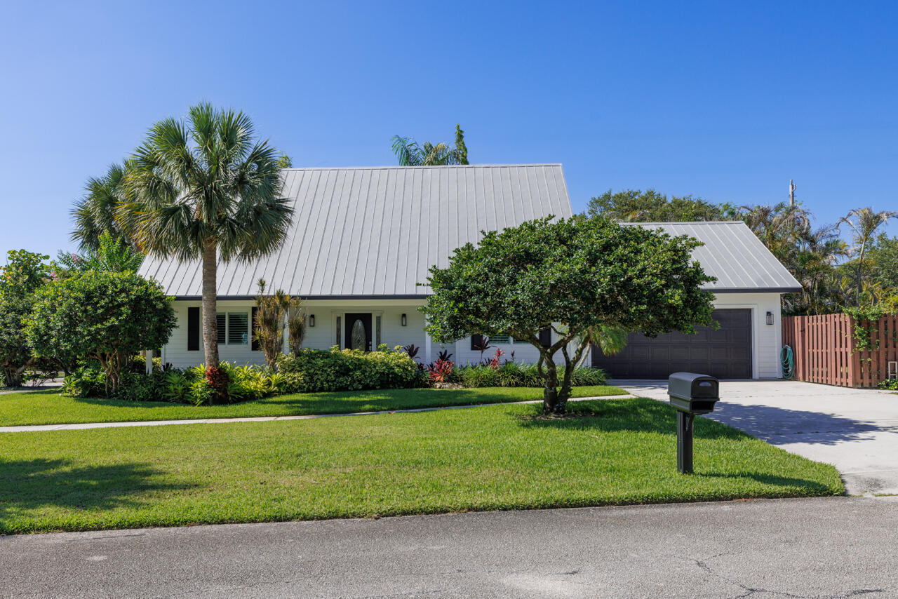 IMMACULATE! MOVE-IN READY! 3/2.5/2 Plus 7x18.5 EXTRA Room & 4 X16 Interior Storage Room.  Master is downstairs.  Two Bedroom& one bath, Huge Rm & Storage located upstairs.  Renovated in 2023. IMPACT WINDOWS, Built-in Closets, Chair-rail, & Plantation Shutters, Polyaspartic Garage floor coating, new flooring - vinyl "wood" & carpeting, renovated baths, updated light fixtures. Home is in "Zeus Park". NO HOA! WALK to BEACH, Downtown, Churches, JV Park, Zeus Park, Schools, & Community Center. Home is located on a corner-offering  privacy. Huge Fenced side yard-great for gardeners, pets, sunbathing, etc. Home is in the Hobe Sound CRA district. CRA is a community redevelopment area-to revitalize historic area Hobe Sound offers a boat ramp at Jimmy Graham Park.