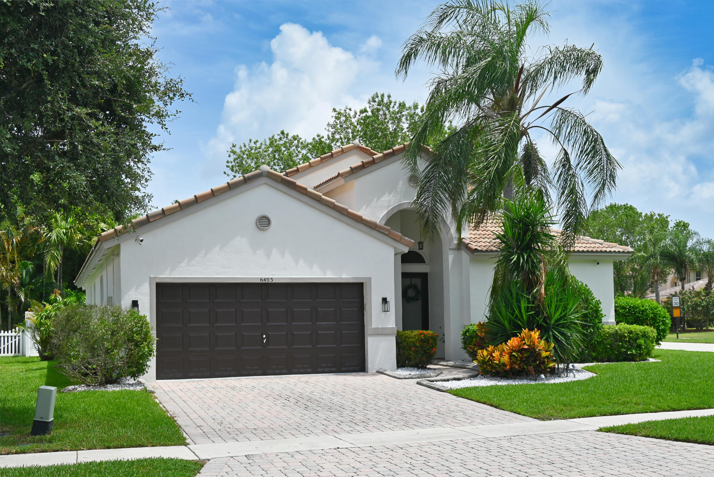 Welcome to this beautifully updated single-story home in the highly sought-after community of Journey's End in western Lake Worth. Offering 4 bedrooms and 3 beautifully renovated bathrooms (2022), this home combines comfort, style, and thoughtful updates throughout. The spacious kitchen is truly the heart of the home, featuring a large center island, abundant storage, and an open layout that flows seamlessly into the inviting family room—perfect for everyday living and entertaining. A welcoming entryway leads to the formal dining area and spacious living room, which opens to a large, screened patio, creating an ideal space for indoor-outdoor living.  Step outside and enjoy your own private backyard retreat, complete with low-maintenance artificial turf and a putting green for year-round fun and relaxation. The generous primary suite offers two large walk-in closets and a beautifully renovated en-suite bathroom. Two additional bedrooms share an updated bathroom, while the fourth bedroom and full bath are tucked away in their own private area, making an ideal guest suite or home office. This move-in-ready home has been thoughtfully updated with new impact windows, new plumbing (2022), fresh interior and exterior paint, recessed lighting throughout, and a beautifully renovated laundry room with a new washer and dryer (2022).  With modern updates, a functional floor plan, and an exceptional location, this home is ready to welcome its next owners.
