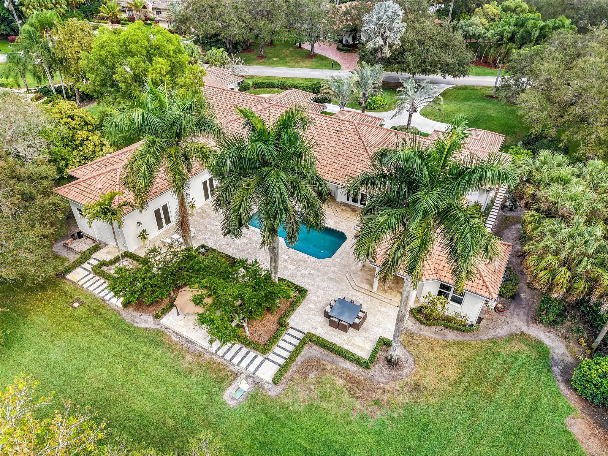 A Home Designed to Be Felt, Not Just Seen! Being sold fully furnished, Turn Key! Perfectly positioned and extensively renovated estate offers a rare combination of luxury, comfort, privacy, and modern convenience. Bathed in natural light through expansive impact windows and doors, the home showcases breathtaking views of manicured grounds and a resort-style heated saltwater pool. Every detail has been thoughtfully reimagined, from the designer lighting to the custom architectural finishes that create an atmosphere of timeless elegance. This is one of the most extraordinary opportunities in Windmill Ranch Estates. Nestled on approximately 1.37 private acres, this extensively renovated estate has been thoughtfully reimagined to deliver an unparalleled luxury lifestyle where every detail has already been considered. A grand arrival begins with an expanded brick-paver driveway, lush professional landscaping, custom impact front entry, and elegant exterior lighting. Inside, natural light pours through impact windows and doors, smooth-finish ceilings, designer lighting, custom window treatments, and beautifully reconfigured living spaces designed for both comfort and sophistication. The spectacular chef's kitchen serves as the heart of the home, featuring a Wolf 8-burner gas range, Thermador refrigerator and freezer columns, Bosch dishwasher, microwave drawer, custom cabinetry, handcrafted plaster hood, pot filler, and Zip Water system providing filtered, boiling or chilled water on demand. Designed for effortless entertaining, the family room and game room showcase custom built-ins, Samsung Frame TVs, a designer entertaining bar, Thermador refrigerator drawers, white oak architectural details, and multiple gathering spaces. The luxurious primary retreat offers custom cabinetry, designer finishes, spa-inspired dual baths with NEOREST TOTO smart toilets, steam system, custom dressing areas, and dedicated Trane climate control. Smart-home features include Control4 whole-home audio, enterprise-grade Aruba Wi-Fi, whole-house water filtration, 10-camera security system, RainBird smart irrigation, new Trane A/C systems, updated water heaters, and extensive infrastructure improvements. Outside, enjoy a heated saltwater pool, summer kitchen, guest house, upgraded outdoor living spaces, and resort-style grounds that create an atmosphere of privacy, relaxation, and effortless luxury. Rarely does a home combine this level of design, craftsmanship, technology, and lifestyle. This is more than a residence, it is one of Weston's most compelling luxury estates.