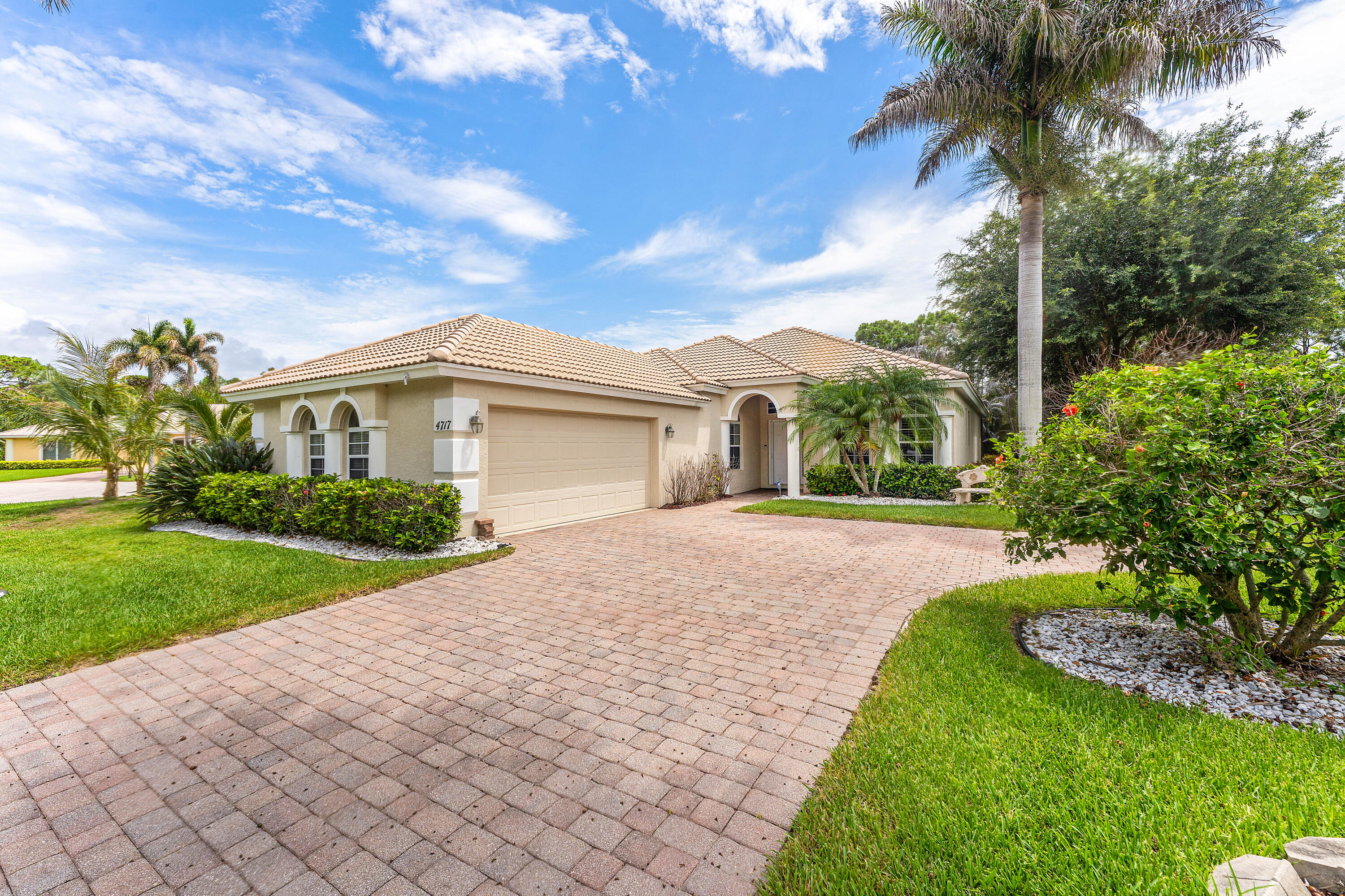 Pool home in the highly sought-after Jensen Beach Country Club. Situated on an oversized cul-de-sac lot, this private tropical retreat offers exceptional curb appeal, lush landscaping, no rear neighbors, and no homes directly across the street. Designed for both comfortable living and entertaining, the outdoor space features a private pool, expansive screened patio enclosure, tranquil views, and an oversized driveway with plenty of parking. Popular split-bedroom Bradford floor plan offers 3 bedrooms, 2 baths, a spacious great room, and dining area. Diagonal tile flooring enhances the main living areas, while the open eat-in kitchen features granite countertops, upgraded cabinets, a breakfast bar, and plenty of storage. The 3rd bedroom is perfectly suited as a home office or study, complete with custom built-ins and French doors. Plantation shutters throughout the home add style and elegance. The spacious primary suite features two closets, including a walk-in closet, and a luxurious en-suite bath with dual sinks, an oversized soaking tub, and a large walk-in shower. Additional highlights include a generously sized laundry room with a utility sink and built-in cabinets. Enjoy the premier lifestyle offered by Jensen Beach Country Club, a gated community with a manned guard gate and outstanding amenities, including three heated pools, tennis courts, pickleball courts, miles of walking and biking paths, and a community clubhouse. The community's 18-hole championship semi-private golf course offers pay-as-you-play access with no mandatory membership. Low HOA fees include lawn care, irrigation, basic cable, internet, and security system monitoring. Conveniently located just minutes from the beaches, downtown Jensen Beach, Pineapple Park, Treasure Coast Square, shopping, dining, healthcare facilities, and top-rated schools. Furniture is negotiable. Buyer to pay a one-time capital contribution at closing.