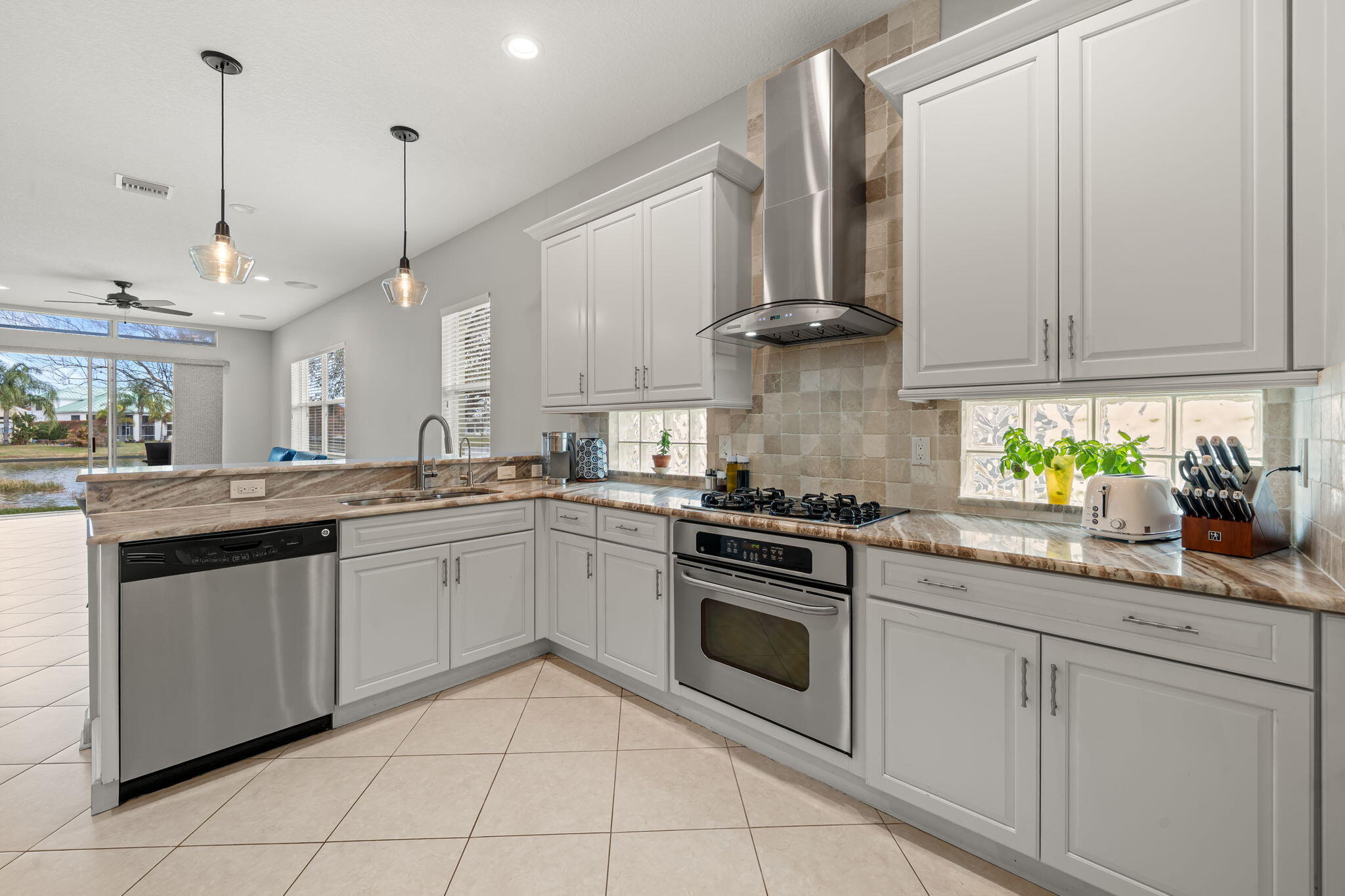 Beautifully renovated 3-bedroom, 2-bath home with a 2-car garage, ideally situated on a corner lot with tranquil lake views. This home was completely remodeled in 2015, including walls, electrical, plumbing, kitchen, bathrooms--everything has been thoughtfully updated. The bright, open kitchen features white cabinetry, granite countertops, and a clean, modern design perfect for everyday living and entertaining. The spacious primary suite offers two closets and a well-appointed bathroom with separate shower and soaking tub. Enjoy both formal living and family rooms, with the family room featuring a wall-mounted large flat-screen TV. Outdoor living is enhanced by two screened patios overlooking the lake, providing peaceful water views and ideal spaces to relax.  Conveniently located near the main gate and resort-style clubhouse, residents enjoy exceptional amenities including adult and children's swimming pools, tennis courts, basketball court, bocce ball, fitness center, billiards, library with WiFi, game room, and more.  HOA fees include internet, cable, lawn care, irrigation, pest control, gated security, and additional community services.  Come enjoy the lifestyle you deserve in this move-in-ready lakefront home.