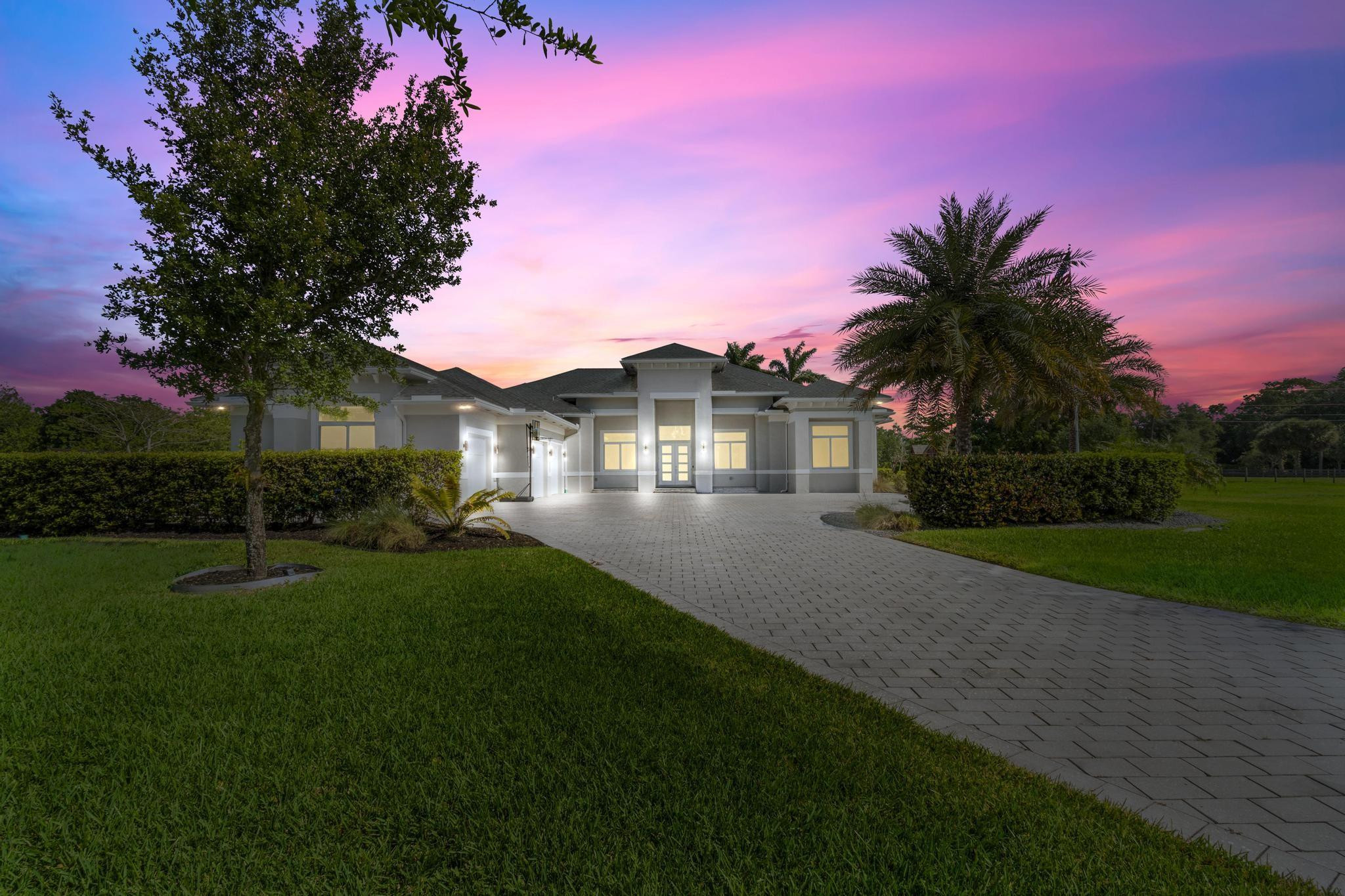 Remarkable Newly Built Modern Estate on 2.5-Acres! Oak-lined paver driveway leads to motor courtyard & statuesque home w/soaring ceilings. Contemporary supersized space galore from the Great Room to the Primary Suite w/Safe-rm to the Ensuites to the dual Patios, resort-styled Pool/Spa/Shelves & full-Summer Kitchen spaces to the Grounds. The finest of custom finishes include 15' tray ceilings, 6" Base, 8' solid wood Doors, Assura Impact Windows/Doors, motorized Blinds, #10-zoned Camera Sec System, LED lighting pkg reflecting over porcelain floor. Gourmet Kitchen fit for the Family Chef features S/S appl pkg amongst white maple wood thermofoil cabinetry w/under cab-lighting enhancing rich charcoal granite tops & functional center island w/ pop-up outlets. 48KW Gen, Solar Gate, Playground, +!