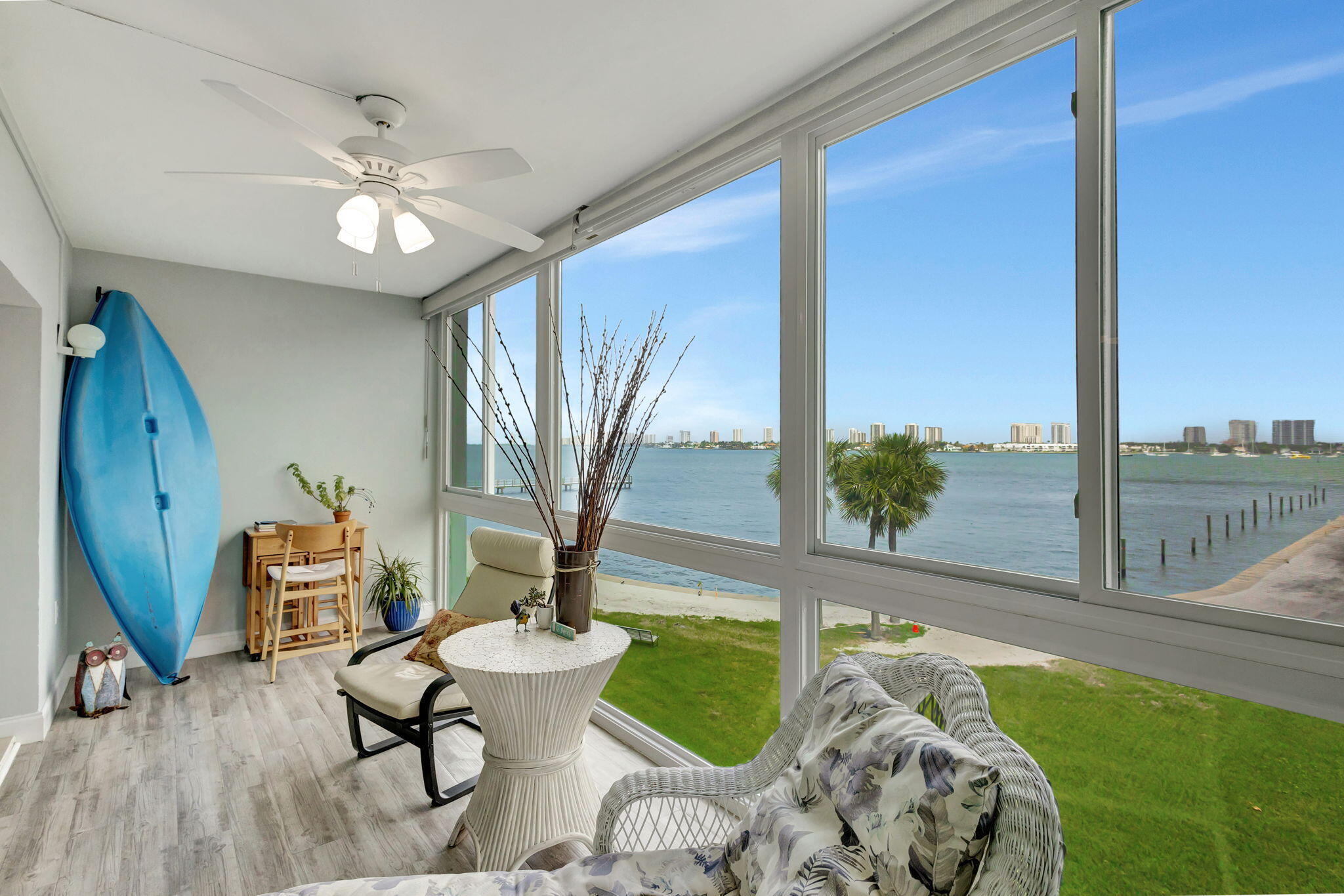 Enjoy spectacular Intracoastal water views from living room and glass-enclosed lanai. Newly installed impact windows (2023).  Many updates include: new air conditioning system (2023), water heater (2024), wood laminate and tile flooring, modern kitchen counters, cabinets, appliances.  New Roof (2026). Seawall restoration in progress, monthly payment is $59.94. Property is easy to show,  Priced to sell..