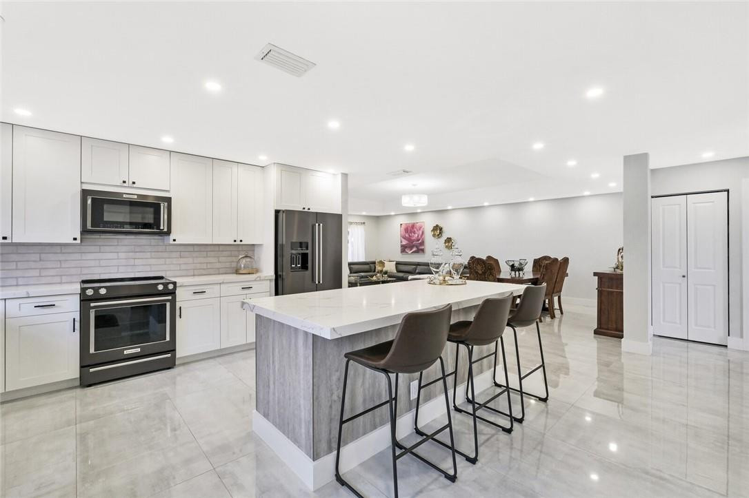This beautiful 3 bedroom, 2 bathroom home has been COMPLETELY REMODELED! The spacious and open floor plan offers a newly renovated kitchen w/ white shaker wood cabinets, quartz countertops, brand new KitchenAid appliances, and a 7ft island. NEW 24x48 porcelain tile floors throughout the common area & luxury laminate floors in the bedrooms. Freshly painted interior AND exterior, new LED lighting, all new baseboards + trim, new light fixtures, remote controlled fans in bedrooms, updated electrical box, 2020 water heater, and NO popcorn ceilings are just a few of many upgrades this home has to offer. Large fenced in yard with screened-in patio & expanded driveway. ALL A-Rated schools. Low HOA includes cable, lawn, garbage, clubhouse and pool. Close to major shopping, restaurants and highways