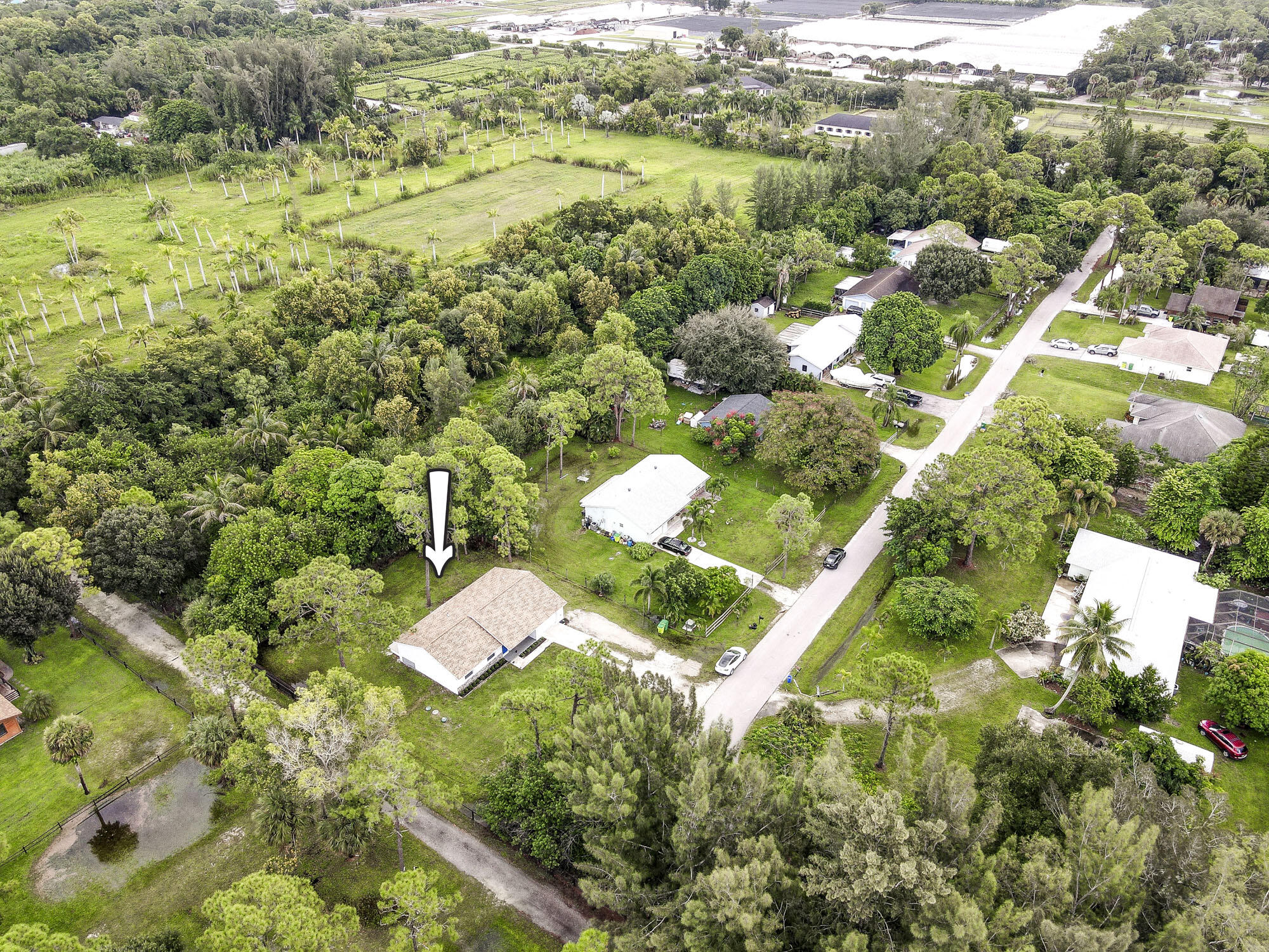 Beautifully renovated 3BD/2BA home located on a paved road in Loxahatchee Groves, just minutes from Royal Palm Beach and Wellington. Situated on a 0.42 acre lot, this serene property offers agricultural/residential zoning, no HOA, and plenty of space for outdoor living. Major upgrades include a NEW 2024 roof, 2024 septic and water treatment system, and fully renovated kitchen, baths, and flooring 2024, hot water heater 2023, A/C 2022. The open floor plan features sleek 24x48 matte porcelain tile and designer finishes throughout. The kitchen boasts quartz countertops, stainless steel appliances, custom cabinetry, and a large pantry. Step outside to a brand-new deck overlooking the private, tree-lined yard—ideal for relaxing or entertaining. and equestrian amenities. Don't miss out on this rare opportunity - schedule your private showing today!