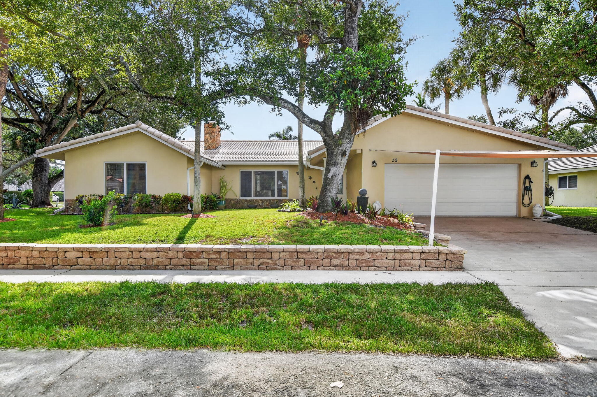 Discover exceptional Florida living in this beautifully updated pool home, perfectly situated on a private corner lot at the end of a quiet cul de sac with NO HOA. Located just minutes from I95, Boca Raton's pristine beaches, Mizner Park, Brightline, premier shopping, dining, and entertainment, this home combines an unbeatable location with over $200,000 in quality improvements.  Every detail has been carefully curated to create a home that is as functional as it is beautiful. Soaring vaulted ceilings, abundant natural light, LED lighting throughout, and an inviting open layout create a warm yet sophisticated atmosphere from the moment you enter. The home offers multiple gathering spaces, including an elegant sunken living room with a wood burning fireplace and a spacious  family room designed for effortless everyday living and entertaining. At the heart of the home is the stunning chef's kitchen, completely redesigned in 2021 to seamlessly blend style and function. Anchored by a large Cambria quartz island, the space features stainless steel appliances, an induction cooktop, custom cabinetry, and generous prep space, making it equally suited for intimate dinners or hosting family and friends. This master bedroom serves as a true retreat. The spacious bedroom offers direct access to the Florida room and features three separate closets, including a walk in closet, a wall closet, and an additional linen closet, providing exceptional storage and organization. The master bathroom was fully renovated within the past year, showcasing dual vanities, a Toto toilet, a beautifully designed walk in shower, and convenient cabana access for the pool. The guest bathroom has also been completely remodeled with timeless finishes and features a custom locking barn door. Every bedroom received new carpeting in 2021, completing the home's move in ready appeal. Designed to embrace South Florida's indoor outdoor lifestyle, the backyard is nothing short of spectacular. A sparkling saltwater pool is surrounded by an expansive travertine deck, creating the perfect setting for entertaining or quiet relaxation. Two custom pergolas define the outdoor living experience. One houses a fully equipped outdoor kitchen featuring both gas and charcoal grills, an outdoor refrigerator, generous countertop space, and everything needed to entertain with ease. The second pergola offers an inviting covered lounge area, creating another destination to gather with family and guests. Surrounded by lush tropical landscaping, the fully fenced backyard feels like a private resort. The modern horizontal wood privacy fence, installed approximately two years ago, is enhanced with low voltage landscape lighting and gate access on both sides of the home. Mature fruit trees and tropical plantings, including lime, cherry, two mango trees, ginger, two banana plants, and kumquat, add beauty and character to this exceptional outdoor oasis. Additional features include impact glass throughout, a tile roof approximately ten years old, a 2021 water heater, two newer air conditioning systems, and an automatic six zone irrigation system. Offering timeless updates, exceptional outdoor living, and an unbeatable Boca Raton location, this is more than a home. It is a private retreat designed for those who appreciate quality, comfort, and the very best of South Florida living.