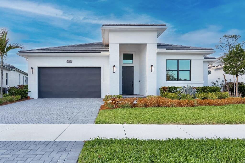 New Construction Without the Wait! This lakefront 3-bedroom, 3-bath home plus den offers over 2,300 sq ft of thoughtfully designed living space with high ceilings and expansive four-panel 10-ft sliding glass doors that fill the home with natural light and open to a large covered patio. The gourmet kitchen features an oversized island, white shaker cabinetry, quartz countertops, and gas range. The primary suite includes a soaking tub and spacious walk-in shower, while one guest bedroom offers a private en-suite bath. Additional highlights include impact windows, gas water heater, epoxy garage floor, sprinkler system, rain gutters, and no carpet. Located in a gated community with resort-style pool, pickleball courts, and fitness center, just minutes to the Turnpike with easy access to I-95. (Note: Some photos have been virtually staged to showcase design inspiration and spatial possibilities - helping you imagine how this beautiful home can be styled to suit your taste.)