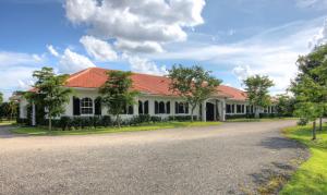This treasure in coveted Palm Beach Point has it all!  The 5.27 acres includes a 12 stall barn with a 2 bedroom grooms quarters, spacious sand riding arena, 6 paddocks, tack room, feed room, storage room and a beautiful viewing lounge.  The newly renovated house with 5 bedrooms and 4.1 bathrooms, includes a new kitchen with granite counter tops, new cabinets and new appliances. The bathrooms also have new vanities and tubs.  A separate entrance leading to a 1 bedroom suite makes it the perfect area for guests, mother in law or nanny. The renovations and upgrades are near completion! Add in the close proximity to the Winter Equestrian Festival and this property has it all! An additional 5 adjoining acres is also available, totaling 10.3 acres. See attached renderings for property options.
