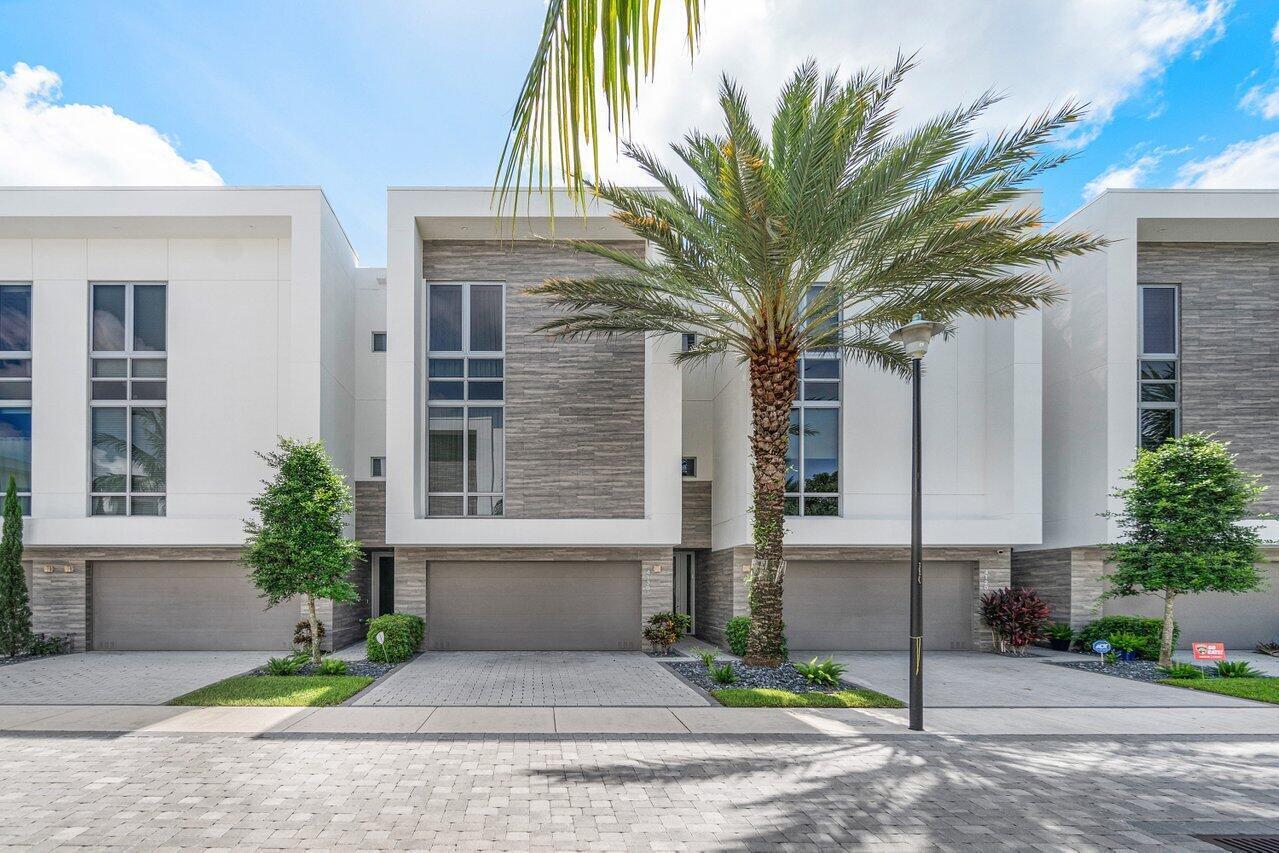 Welcome to 4130 at Moderne, a gated contemporary enclave in the heart of Boca Raton. This three-story townhome with elevator is the largest model in the community, offering nearly 3,000 square feet of modern living space and positioned on one of Moderne's most desirable lots backing directly onto the 76-acre PondHawk Natural Area preserve. With views of the preserve at every level, this unit is flooded with natural light from the expansive windows and 10-foot ceilings. Arguably the best floor plan in Moderne, the open concept design seamlessly connects the living, dining, and kitchen areas, creating an ideal setting for both everyday living and entertaining. The private, paved and turfed backyard offers an ideal space for low maintenance enjoyment and the concrete block construction ensures quiet within the home. The upgraded gourmet kitchen and laundry room are outfitted with premium brands including Porcelanosa, Grohe, Jenn-Air, and Electrolux. Smart home features offering modern technology for comfort and security, include a Ring security camera system, alarm system and Sonos surround sound speaker system.  Additional highlights include oversized Italian porcelain tile flooring, quartz countertops, upgraded cabinetry, custom closets, designer light fixtures, a full laundry room and impact glass throughout. The serene primary suite features dual walk-in closets, a built-in morning bar with mini fridge and a spa-inspired bathroom. Residents of Moderne enjoy a gated entrance, resort-style pool, and fitness center. Ideally located in central Boca Raton just minutes from beaches, Mizner Park, Town Center Mall, top dining, and major conveniences, this home offers a rare combination of privacy, location, and stunning contemporary design. An economical and convenient furniture package is available for the buyer for immediate move in.