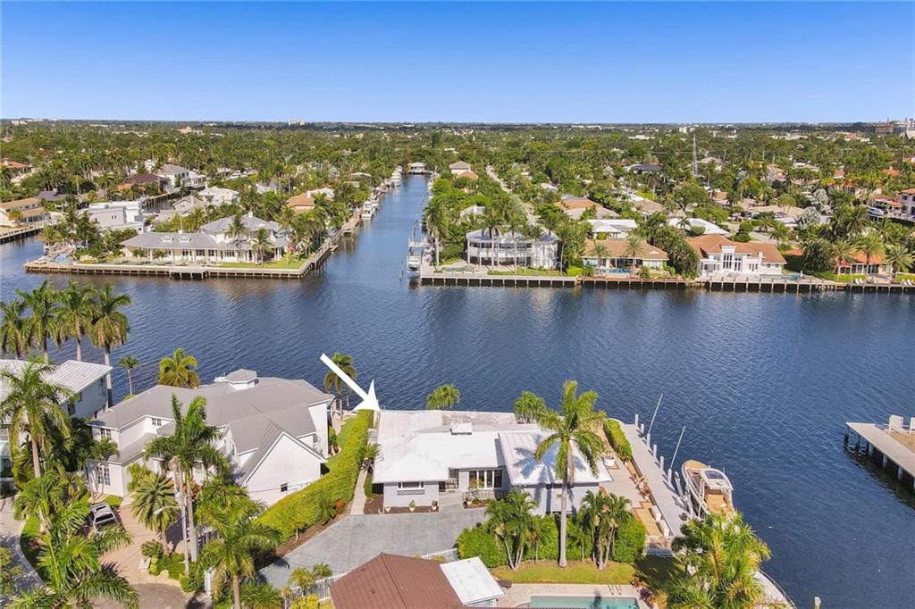 This amazing point lot has over 200 feet of waterfront with 100+ on the intracoastal. Brand new seawall upgraded to existing standards surrounds the property and includes a 27,000 pound boatlift.  Existing Three bedroom, 4 bath home is lovely with a mid century design and gorgeous Ketchum/Cuban tile floors, recently updated with fresh paint and modern lighting. Completely renovated guest suite includes one bedroom /one bath above the garage, two bedrooms and two baths in the existing house. Ready for your custom designed home or live in the existing charming home.Amazing views, amazing potential!