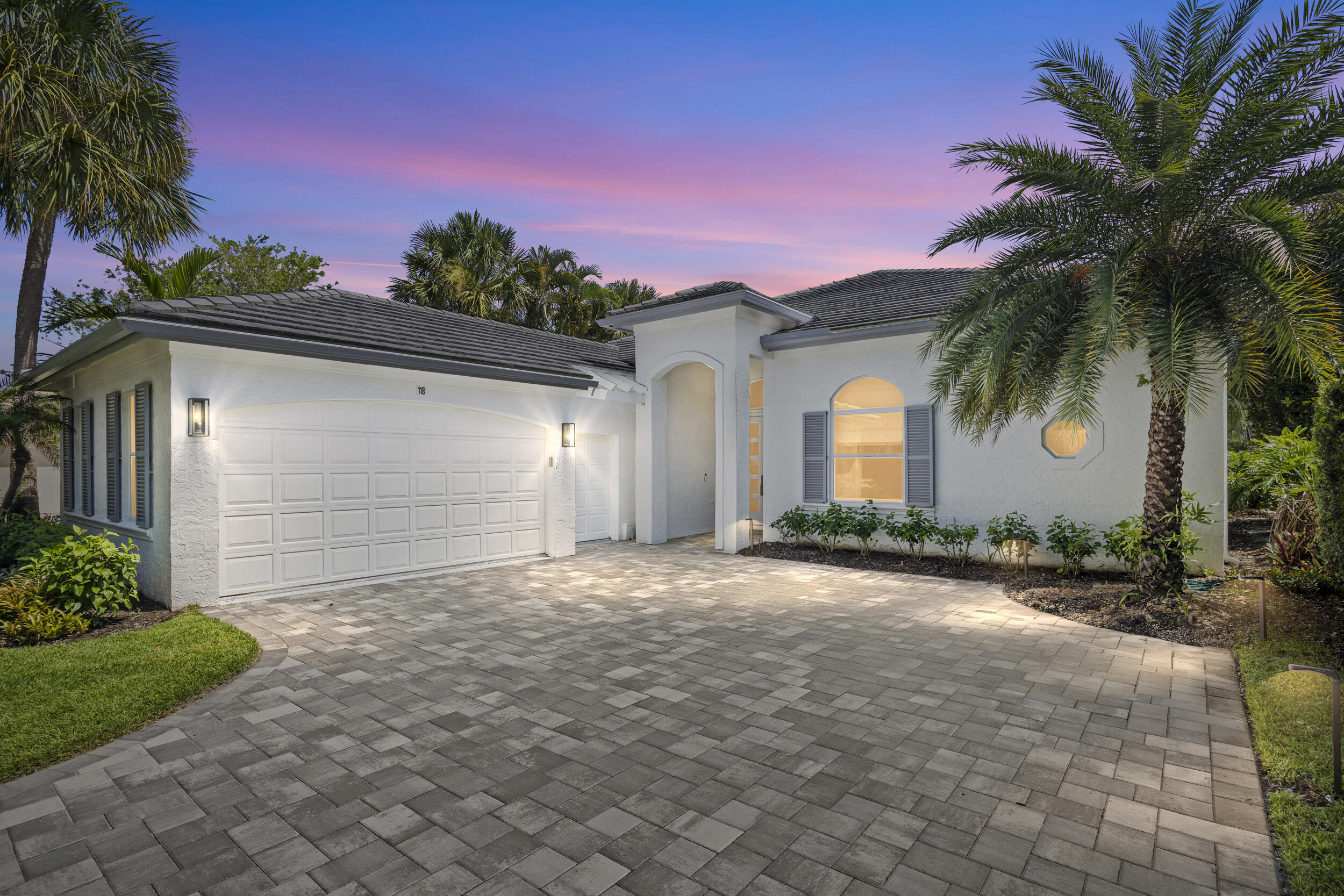 Experience elegant coastal living at 118 N Village Way, a turnkey gem nestled in Jupiter's exclusive Admirals Cove Golf Village. This single-story, CBS-built home blends crisp contemporary interiors with subtle luxury and a relaxed ambiance. Featuring 3 bedrooms, a flex room, 3.5 baths, and a 2.5 car garage the residence is designed for both comfort and elegance. Gather in the sophisticated living area with wet bar, or cook in the chef's kitchen opening to a lush entertainer's patio and heated pool & spa with golf and lake views. Complete with impact glass windows and beautiful curb appeal, you'll enjoy the amenities of a Platinum Club from golf, tennis, dining, wellness, a private marina and so much more all located in a secure, gated environment.