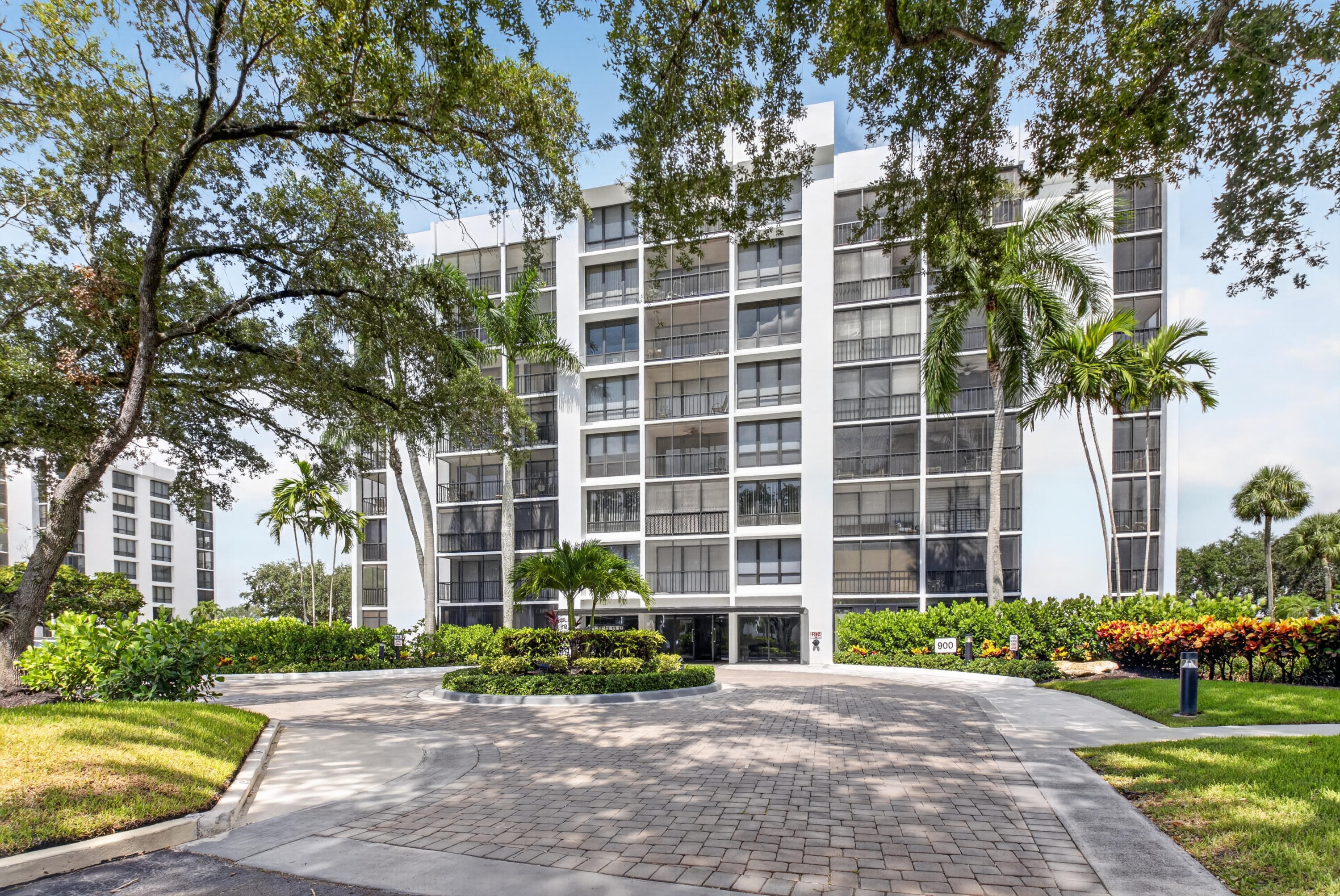 Beautifully fully renovated 7th floor corner Midrise apt. surrounded by lushly landscaped trees and palms. Southeast exposure. Custom upgraded finishes throughout. Large 48" x 48" oversized white porcelain tiles with grey veins throughout. Small patio glassed in and open to living areas. All new appliances, W/D,  water heater & electrical panel. Custom closets.  Full wall mirror. Keyless entry system. Modern clean lined interior features LED high hats, LED mirrors & pendant lighting over kitchen bar area. Kitchen is finished with a quartz full piece backsplash, under counter lighting. Bar area complete with a wine cooler. All rooms Hotwire ready. A very light and bright apartment. NOTE: Golf cart storage spot available.