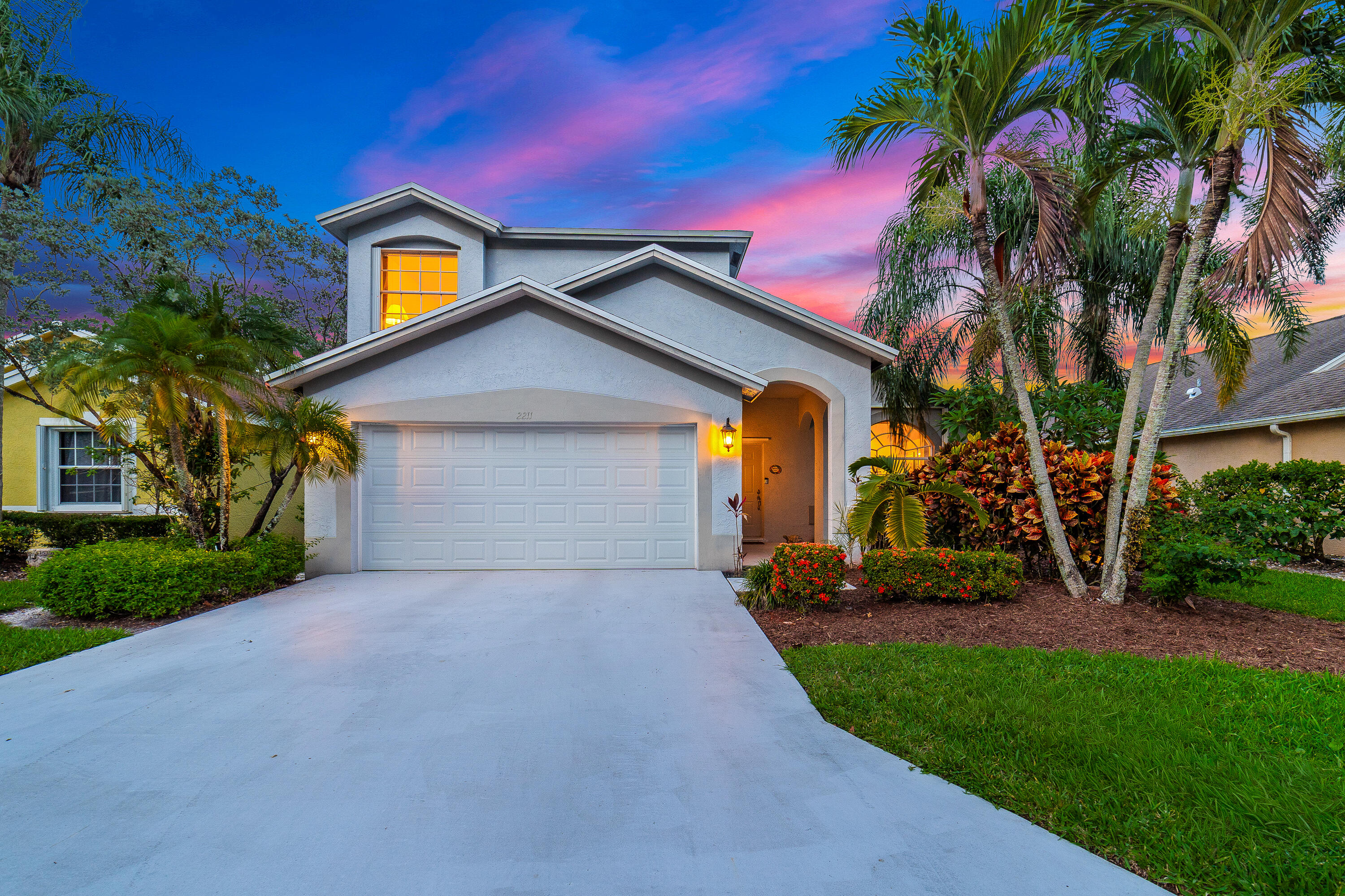 Welcome to this exceptional, meticulously maintained two-story home in the highly desirable community of Riverbridge. Offering 4 bedrooms and 2.5 bathrooms, this residence features a spacious and functional layout with the primary suite conveniently located on the main level. Inside, you'll find soaring vaulted ceilings, neutral finishes, tile flooring throughout the main living areas, and both formal living and family rooms designed for comfortable everyday living and effortless entertaining. The updated eat-in kitchen flows seamlessly into the living spaces, creating a warm and inviting atmosphere. Step outside to an expansive 12' x 40' screened patio overlooking tranquil waterfront views, the perfect setting for morning coffee, outdoor dining, or relaxing evenings.  Additional highlights include custom blinds, accordion shutters, an attached 2-car garage, new carpet in the bedrooms and staircase, and freshly painted interior rooms. Riverbridge offers an exceptional lifestyle with resort-style amenities including a 24/7 manned gate, clubhouse, pool and spa, fitness center, movie theater, and game room. Ideally located near top-rated schools, golf courses, Okeeheelee Park, Riverbridge Shopping Center, and just minutes from Wellington Green Mall, dining, shopping, and area beaches.