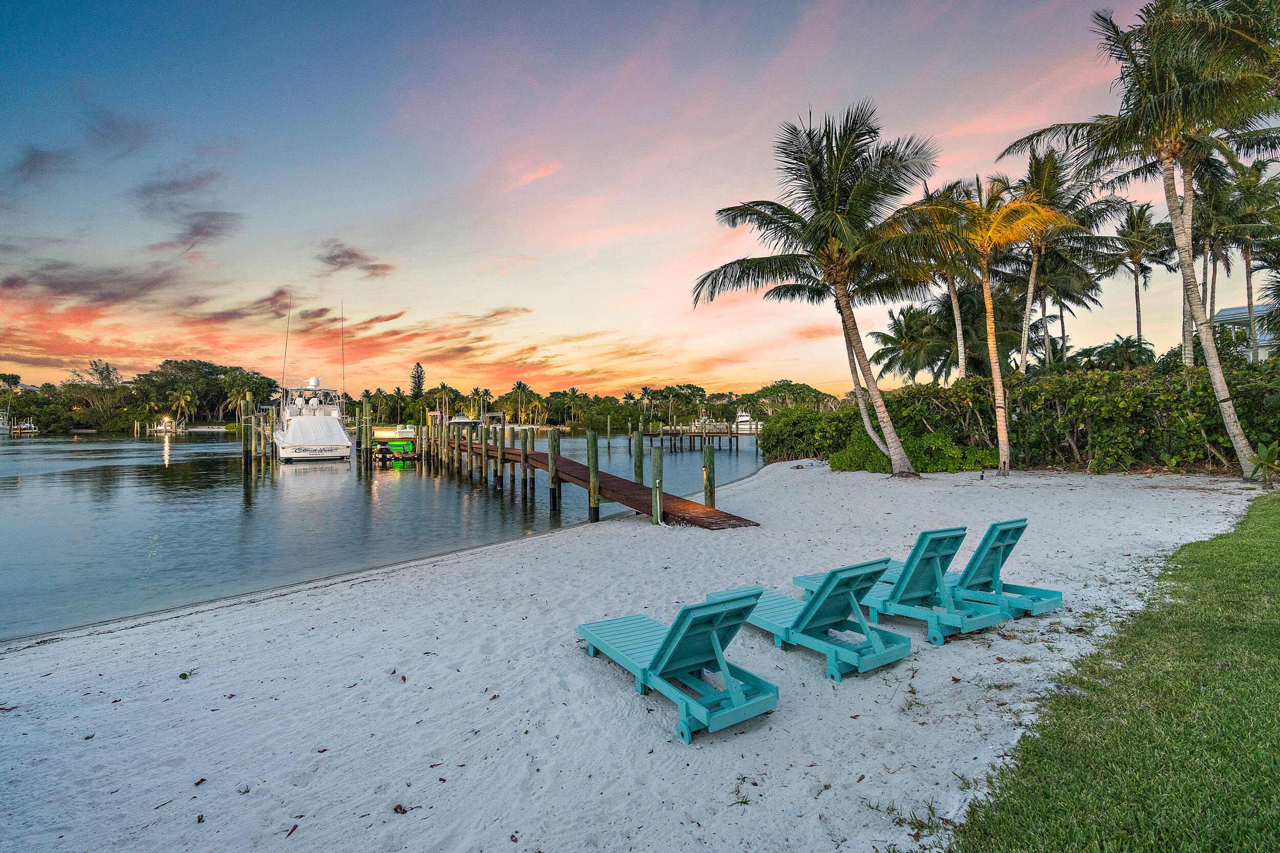 On 100 feet of blue, Intracoastal waters this plantation-style estate on 3.3 acres has 4 structures; the Residence, the Carriage House, the Guest Cottage & Poolside Cabana.  Also a Pool, Tiki Hut, sandy beach, fully equipped dock and SO much more! The gate opens to an impressive winding drive, past the 4-bedroom Cottage on the right & the Carriage House on the left with living quarters above. As you enter the main residence, the charm of this Southern plantation colonial greets you with gorgeous cherry floors, formal dining & study with fireplaces, soaring ceilings, a fabulous staircase & a stately openness that is breathtaking! The living areas lead out to the loggia, a fantastic area for entertaining, overlooking the blue waters of the Intracoastal. The kitchen is strong in architectural detailing & has every amenity including a butler's pantry & a secondary laundry area. The south side of the home is complete with a billiard room, a bar & a media room! The master suite has its own massive lanai overlooking the 700 ft. water span to Jupiter Island. The guest suites are on the second floor, with the primary laundry room as well. The resort quality pool is 55 x 30 & has a beach style entrance at one end, a dramatic rock wall waterfall & a hidden slide at the other end just steps away from the Tiki hut, fire pit, karaoke stage & a 70 ft. by 30 ft. Sugar Sand Beach! The 145 ft. dock stretches out into the Intracoastal with a 25k boat lift & room for a yacht, a boaters dream.