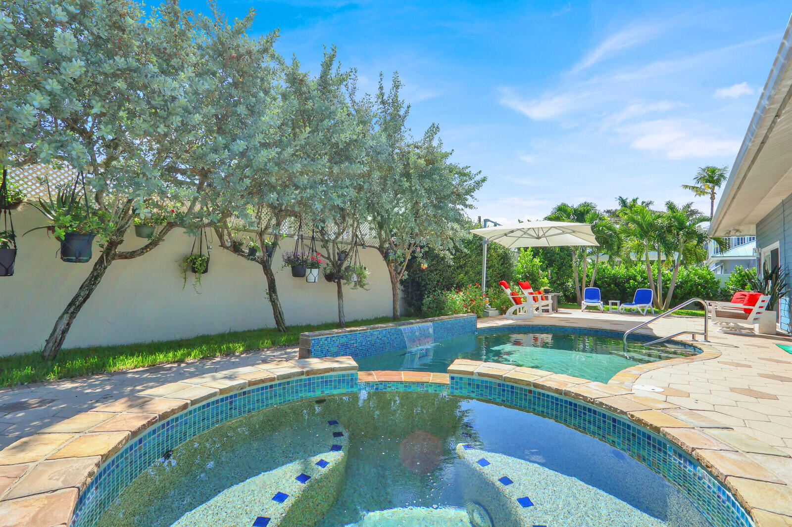 Experience the charm of a Key West-inspired retreat in the heart of Jupiter. Nestled in a sought-after coastal neighborhood with a private boat ramp offering ocean access, it's the perfect place to launch smaller boats, kayaks, and paddleboards. Inside, nearly every detail has been thoughtfully renovated and updated, creating a fresh, move-in-ready home. Hurricane-ready impact windows and doors provide peace of mind, while the standing seam metal roof was replaced in 2021. The impressive list of upgrades includes custom lighting, a wine cooler, water softening system, a solar-heated pool, custom closet storage, wood-look plank tile flooring throughout, and so much more.