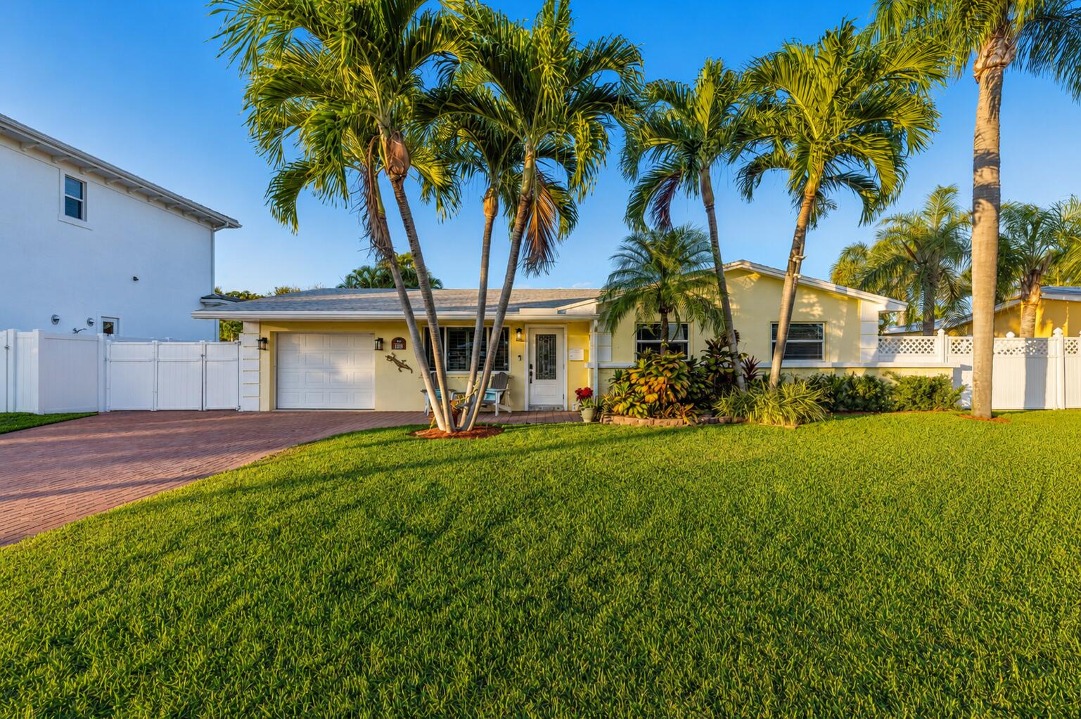 Set along a deep-water canal on a quiet cul-de-sac within one of North Palm Beach's most established, family-friendly streets, this waterfront residence reflects a calm, considered approach to coastal living one that values both refinement and function. With 80 feet of seawall, a decked-over dock, and two boat lifts rated at 16,000 and 12,000 pounds, the property offers seamless access to open water and a lifestyle shaped by time spent outdoors. Inside, light-filled interiors unfold through an open layout that maintains a constant visual connection to the water. The 2024 kitchen is intentionally curated, finished with quartzite countertops, a gas cooktop, wall oven, and new stainless-steel appliances, balancing everyday usability with elegance. The oversized primary suite is set apart as a private retreat, offering dual walk-in closets and a spa-style bath with a two-person Jacuzzi tub, double shower, and dual vanities. Two additional bedrooms with hardwood floors provide flexibility for guests or home office use. A generous family room, anchored by a gas fireplace and a built-in wet bar with beverage refrigerator and quartzite countertops, opens through a full three-panel slider to an oversized, vaulted-ceiling covered patio and expansive paver pool terrace. Outdoors, a custom 2014 pool equipped with an air chiller overlooks the deep-water canal, creating a seamless indoor-outdoor setting well suited for entertaining. Recent updates include a new roof (2024), gas water heater (2025), plantation shutters, crown molding, and solid-core doors, resulting in an enduring expression of modern coastal living.