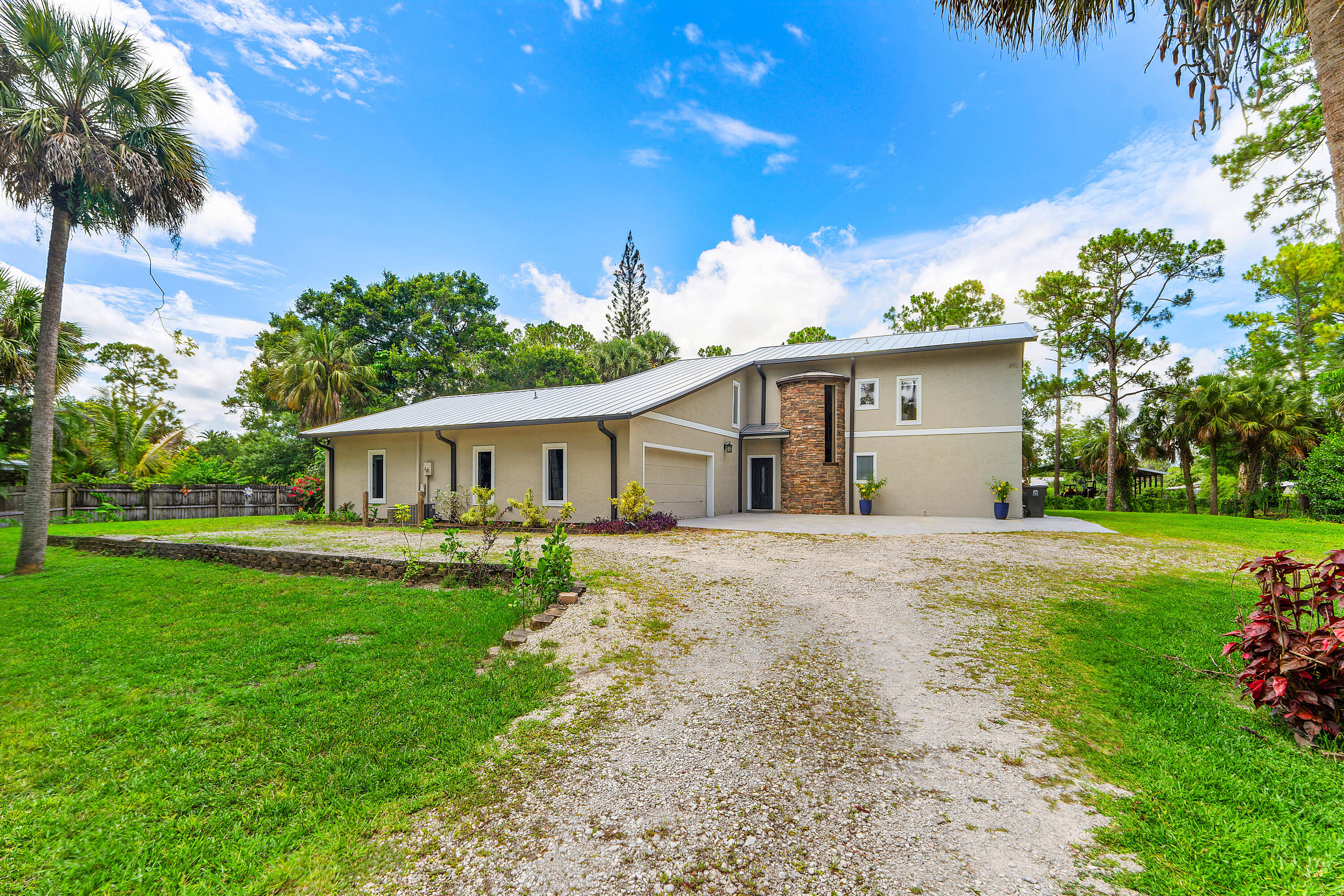 Discover your dream home at 9743 169th Ct N, Jupiter, FL 33478. This inviting property features an open floor plan with soaring ceilings, a cozy fireplace, and an updated kitchen with granite countertops, blue cabinetry, and a charming breakfast nook. A standout feature is the separate mother-in-law suite with its own private entrance and pergola-covered outdoor space, ideal for extended family, guests, or rental income. This unique setup creates an excellent dual-income opportunity for homeowners and investors alike. The primary suite offers private outdoor access and a luxurious bath, while the covered patio overlooks the private backyard. Combining comfortable living with income-producing potential, this Jupiter Farms property is a rare find.