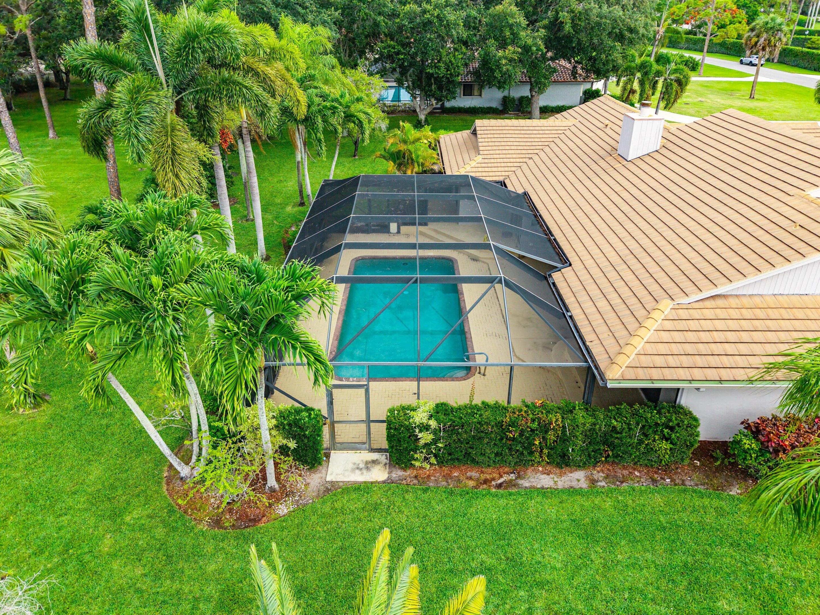 Experience refined Florida living in this meticulously maintained residence ideally positioned along the future 14th hole of the highly anticipated NOKOSI Golf Course, a private Jack Nicklaus-designed course scheduled for completion in the fourth quarter of 2026. Nestled within a unique and highly desirable community of homes, all situated on one acre or more, this exceptional property offers a rare combination of privacy, space, and views. Surrounded by lush landscaping, fruit trees, and swaying palms, the setting feels both tranquil and exclusive. From the moment you arrive, the home impresses with outstanding curb appeal, a grand circular driveway with additional parking, beautifully manicured landscape beds, and an elegant paver walkway leading to the double-door front entry. Inside, freshly painted interiors, terra cotta flooring throughout the main living areas, oversized sliding glass doors, and abundant natural light. All creating an inviting and sophisticated atmosphere. The spacious living room is anchored by a charming wood-burning fireplace and seamlessly opens to the screened pool and patio area, perfect for effortless indoor-outdoor entertaining. The kitchen features stainless steel appliances, a breakfast nook with pool access, and convenient proximity to the formal dining room or optional office space. The private primary suite is a true retreat with new luxury vinyl flooring, fresh paint, two walk-in closets, a soaking tub, walk-in shower, and direct access to the pool and patio through sliding glass doors. Secondary bedrooms are thoughtfully split from the primary suite and share a well-appointed bath with a soaking tub, walk-in shower, and linen storage. Additional highlights include a 2020 roof, 2024 AC, hurricane protection for all windows, new attic insulation & ductwork, ceiling fans throughout, a spacious laundry room with soaking tub and cabinetry, and irrigation supplied by well water for the entire yard. The screened pool enclosure provides the ideal setting to enjoy Florida's year-round lifestyle in comfort and privacy. This exceptional home combines timeless character, thoughtful updates, and a premier golf course setting in one remarkable offering.