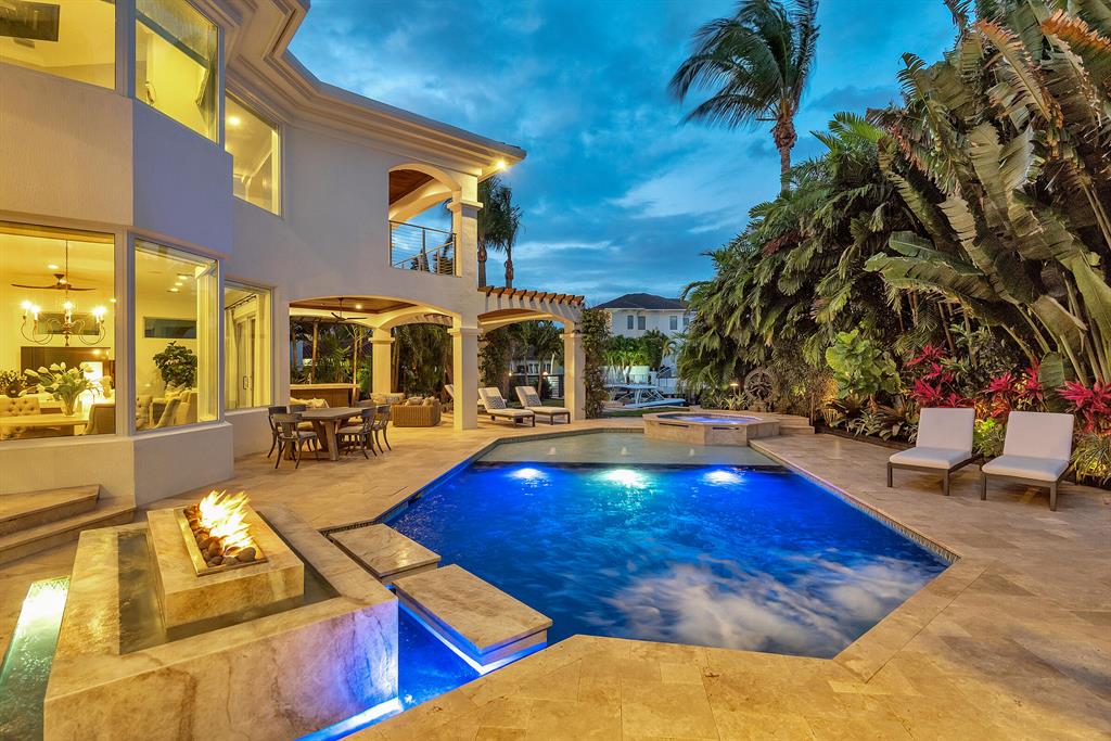 Are you seeking a lavishly luxe home with an outdoor poolside oasis, intoxicating Intracoastal views, and an elegant 1,100 sq ft primary suite? Idyllically nestled on an oversized corner lot, this 4BR/4.5BA, 4,710 sq ft executive residence offers unparalleled beauty with Mediterranean architecture, lush tropical landscaping, and a grand double door entrance. The wood flooring flows throughout the house; soaring ceilings, double height windows, an expansive great room, and a gourmet kitchen featuring premium appliances, new quartz counter-tops, center island with a prep sink and walk-in pantry. Masterfully designed for modern entertaining, the private backyard includes a redesigned heated swimming pool/spa, sprawling patios, luscious greenery, dockage, new pergola, prep island with sink and walk-in pantry. Masterfully designed for modern entertaining, the private backyard includes a redesigned heated swimming pool/spa, sprawling patios, luscious greenery, dockage, new pergola, prep island with sink and top of the line Naturekast waterproof cabinetry. Delightfully private, the 2nd level resort-inspired 1,100 sq ft primary suite includes a walk-in-closet plus new extra custom closet cabinetry, a Sunlighten far-infrared sauna, and a balcony with unsurpassed views of the Intracoastal waterway. The renovated primary en-suite captivates with a stand-alone soaking tub, dual vanities, premium finishes, and a separate rain shower. All additional bedrooms are located on the main floor. Other features: a new sea wall, dock decking with Azek materials, optional jet skis and floating dock (negotiable), attached 3-car garage, Tesla charging port, new electric panels, custom paved circular driveway, laundry room, separate library/office, wet bar, new impact windows/doors and new foam insulation throughout. Close to shopping, restaurants, highways, Publix, Walgreens, Bark Park Dog Beach, Spanish River Park, medical facilities, schools and much more. Start living the good life today! Call now to schedule your private tour.