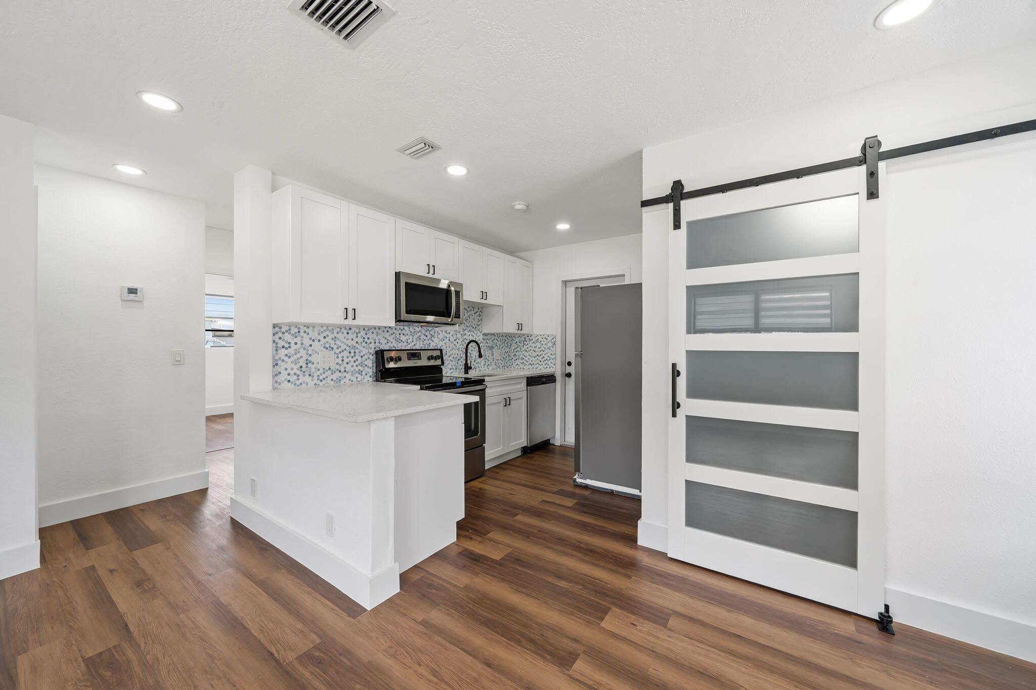 NO HOA! Fully renovated 2BR/1BA home featuring a new 2026 roof, 2026 A/C, and 2026 water heater. The bright, modern interior offers luxury flooring throughout, a beautifully updated kitchen with quartz countertops, white shaker cabinets, stainless steel appliances, and a remodeled bathroom with contemporary finishes. Situated on an oversized lot with room for RVs, boats, future expansion, or a potential ADU/guest house (buyer to verify); ADU rendering available. Conveniently located minutes from Downtown West Palm Beach, Clear Lake, Lake Mangonia, I-95, shopping, dining, and the exciting redevelopment transforming the area. Move-in ready with endless potential! 2026 Roof 2026 A/C 2026 Water Heater New Kitchen