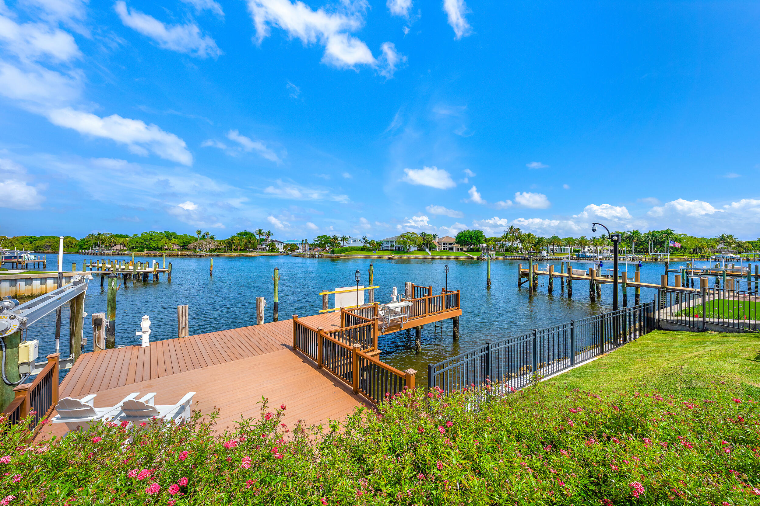 Wake up to breathtaking sunrises over wide Intracoastal views from this rare no-wake waterfront estate offering direct ocean access with no fixed bridges, just minutes from the Palm Beach Inlet. With no HOA and coveted eastern exposure, enjoy peaceful mornings, cool afternoon breezes, and protected deep-water dockage accommodating multiple vessels right from your backyard. Designed for both everyday living and effortless entertaining, the home offers over 5,000 square feet, five private ensuite bedrooms, soaring ceilings, and a waterfront office. Recent improvements include a new copper-detailed roof, refreshed hardscaping, and an oversized 3-car garage with lifts—creating a rare combination of privacy, protected dockage, and premier waterfront living.