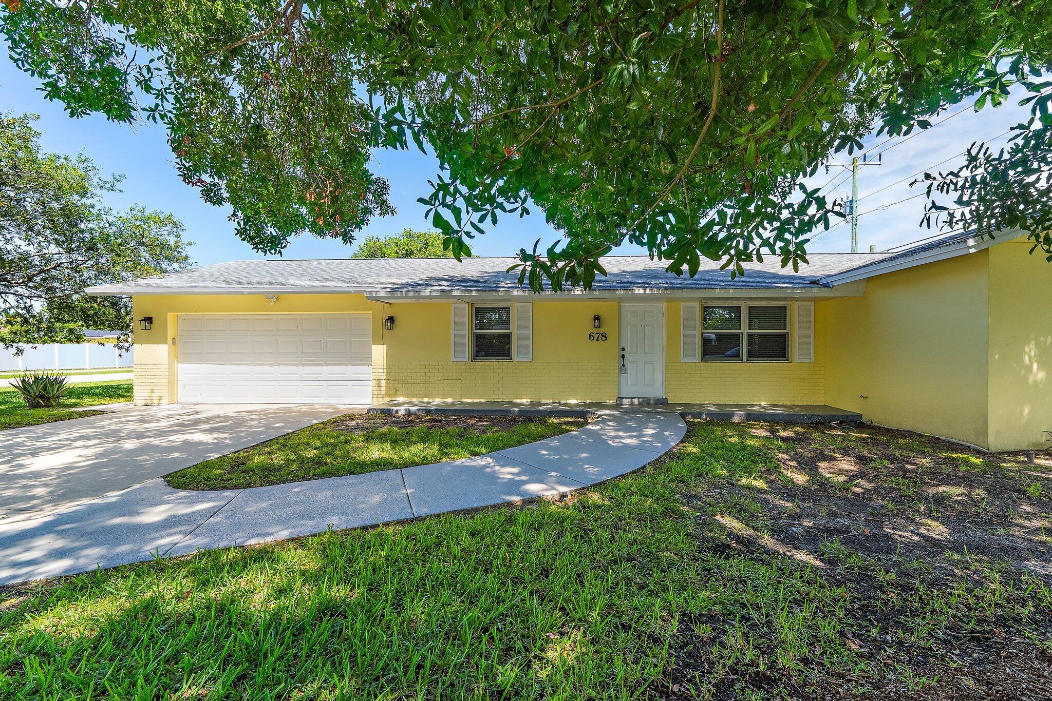Located in Palm Beach Gardens Estates, this four-bedroom, two-bath CBS home sits on a 0.21-acre corner lot with no HOA and a 2022 roof. Conveniently located just minutes from I-95, the property offers 1,305 square feet of living space, an attached garage, and a split-bedroom floor plan.  The kitchen opens to the main living area, creating a functional layout for everyday living and entertaining. The split design provides privacy for the primary suite, while three additional bedrooms offer flexibility for guests, a home office, fitness room, or hobby space. The attached garage provides ample room for parking, storage, or workspace. With a corner lot location, no HOA restrictions, and solid concrete block construction, this home offers both convenience and versatility in the heart of PBC.