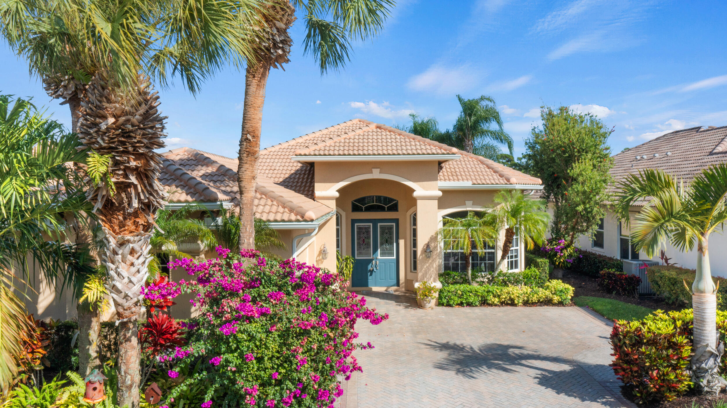 Let's craft a win-win deal and make this piece of Florida paradise YOURS!  New tile roof installed late 2025!  Are you seeking a home with a water view...in a gated community...with access to optional golf and social memberships?  Need a space where you can have room to entertain large groups?   I've got the perfect match for you.  This is a one-owner home presented with undeniable pride of ownership and a warmth that grabs you as soon as you walk in.  The claim to fame is that this was the first home built behind the South Gate of PGA Village back in 2000.  Ready for the next set of owners to create new memories. As soon as you enter the spacious foyer, you will notice the bright and open floorplan with an immediate view of the lake through the sliders. To the right is the formal dining room, where if you peek out the window, you'll see an AMAZING orchid plant hanging from the tree.  When it blooms, it's stunning!  To the left is the first guest room, which has a Murphy bed in the place of where a closet was intended.  (Murphy bed will convey with sale.)  There is a half-bathroom across the hall.  Consider this a dual master, as the second guest room has its own bathroom with tiled shower and updated vanity.      In the owner's suite, you'll find tray ceilings, dual walk-in closets, and a showstopper bathroom equipped with dual sinks, vanity counter, tub, separate shower, and private toilet room (what fancy people call a water closet).  Wake up in the morning to the glowing sun over the lake through your bedroom windows.    The kitchen has beautiful wood cabinets, granite countertops, stainless steel appliances, and undercabinet lighting.  When designing the kitchen, the owners were smart to install a hidden power strip under the cabinets, so that they didn't have to have outlets cut into the backsplash.  The oversized breakfast nook is a direct extension to the kitchen and has housed many gatherings with a super long table and over 20 guests.   The massive lanai features a covered and screened area to stay out of the weather and a space big enough for a dance party!  You'll also find a hot tub installed in the deck, for those nights where you just want to have a soak!   Out front, the paver driveway leads to the side-entry 2-car garage, which also includes an additional golf cart garage space.  Need a workshop or office in addition to the home's interior space?  The Sellers have supplied heat and A/C to the garage and partitioned/screened off an area to create an office and painting studio.  This is a great way to extend the usable space of the home while still having ample room to park a vehicle.       Big ticket updates include the A/C and water heater (2022) and roof (2025).   PGA Village is a very active community that has something for everyone to do.  It's like living in a resort.  Stay fit by taking a swim in the resort style pool, playing a game of pickleball or tennis, shooting some hoops at the basketball courts, or bring the kids to the playground.  If you want to stay inside, check out the clubhouse where you can work out in the fitness center, shoot a game of pool, relax in the library, or join a friendly card game.   Golf and social memberships are available, but not required.    The photos speak for themselves, but you've got to make an appointment and see this place in person to truly appreciate it!  Call and book your private showing today!