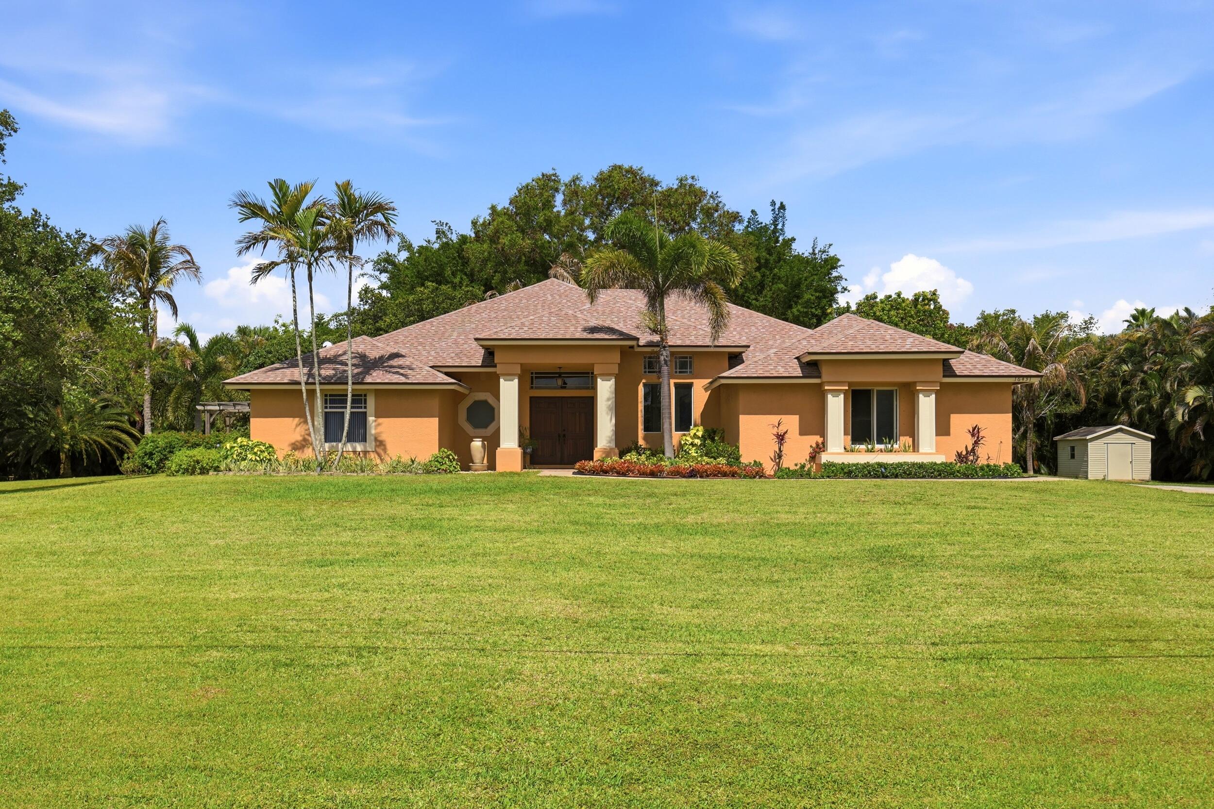 Absolute Stunner in Palm Beach Country Estates! This beautifully maintained 4-bedroom, 3-bath CBS pool home with a 2-car garage sits on 1.15 private acres and features a new roof, storm protection, vaulted ceilings, and an open floor plan.  The updated kitchen offers 42-inch shaker cabinets, newer appliances, and abundant storage. Enjoy formal living and dining rooms, a spacious family room, and a luxurious primary suite with a walk-in shower, soaking tub, dual sinks, and large walk-in closets.  Step outside to your own backyard retreat featuring a 30' x 15' pool, huge patio, and plenty of room to relax and entertain. Offered for sale for the first time, this immaculate home has been lovingly cared for and is truly move-in ready. The only thing missing is its new owner.
