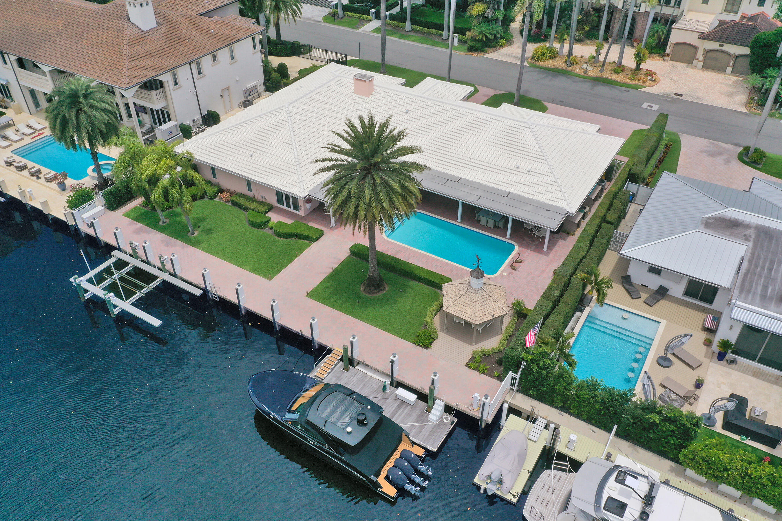 120ft on the water - An elegant waterfront opportunity awaits just seven homes from the point, situated on a rare 14,000-sqft lot along a deepwater canal ideal for large yachts. This exceptionally maintained, expansive single-story ranch estate features high-end finishes throughout. Designed for effortless entertaining, the residence boasts formal living & dining rooms, complemented by a generous family room. The true chef's kitchen is equipped with a gas cooktop, four ovens, 2 dishwashers, and a built-in refrigerator. A massive primary suite overlooking the pool offers WICs and a spa-like bath. Complete with oversized en-suite guest bedrooms, an air-conditioned garage, and a whole-home generator. Other features include a covered patio, heated pool, boat lift, floating dock and much more!