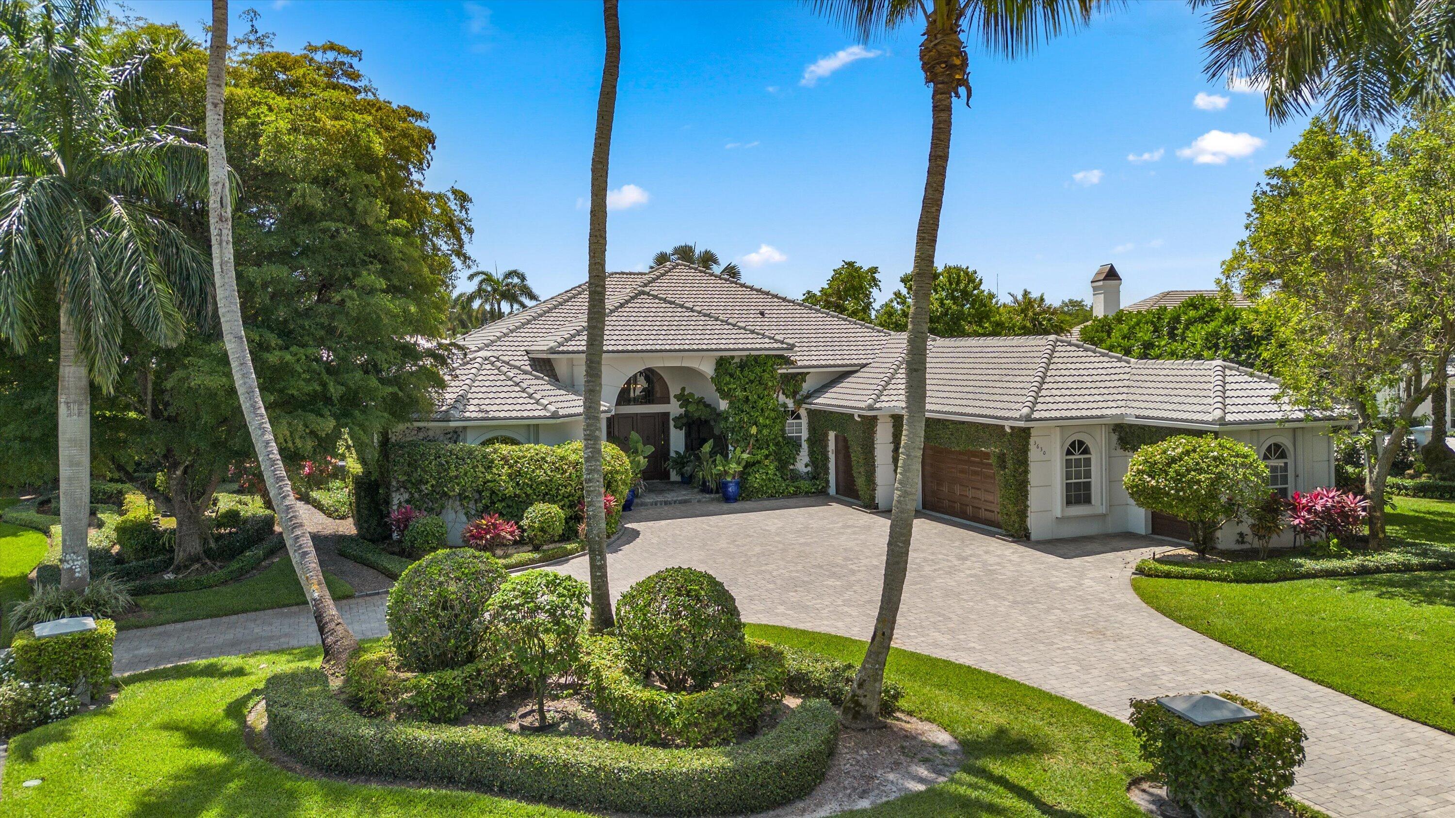 Nestled on a prime oversized corner lot in the coveted Equestrian Club Estates, this exceptional 3-bedroom, 3.5-bath residence is ideally positioned just a short golf cart ride or walk from the show grounds of Wellington International.  Situated on approximately 0.6 acres, the property features a desirable split floor plan and spacious 3-car garage. The private primary suite is complete with dual walk-in closets, separate vanities, and a spa-like primary bath featuring an oversized walk-through shower.  Surrounded by mature landscaping and lush greenery, the home showcases marble and wood flooring, formal living and dining spaces, a spacious family room, and a wood-paneled office complete with a custom Murphy bed for additional guests. Designed for seamless indoor-outdoor living, two screened entertaining spaces include a covered lanai and summer kitchen overlooking the heated pool and spa, serene water views, and generous green space.  Ideally positioned just moments from the show grounds, this exceptional residence offers the rare convenience of being a short walk or golf cart ride from Wellington's premier equestrian venues while still providing the privacy and tranquility to unwind after a day of equestrian competition.