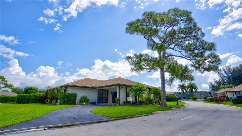 Welcome to 429 Pine Villa — a stunning coastal-inspired retreat where timeless Florida charm meets modern luxury. Completely reimagined with exceptional designer finishes throughout, this move-in-ready 3-bedroom, 2-bath residence offers the feel of a brand-new custom home in one of the area's most desirable gated communities. Step inside to discover a bright and airy open-concept floor plan designed for both effortless entertaining and everyday comfort. Natural light pours through the home, highlighting the beautiful luxury vinyl plank flooring, elegant recessed lighting, and upscale designer fixtures throughout. The inviting Florida room provides the perfect space to unwind and enjoy peaceful evenings year-round. At the heart of the home is a showstopping custom kitchen featuring  soft-close cabinetry, dramatic quartz waterfall countertops, a striking full-wall tile backsplash with open shelving, and premium upgraded appliances — a true dream for both cooking and entertaining. The luxurious owner's suite is a private sanctuary complete with hurricane-impact sliders leading to the patio and a spa-inspired en-suite bath showcasing dual vanities, an oversized tiled shower, soaking tub, and a state-of-the-art smart toilet. Outside, enjoy your own oversized private backyard oasis with an expansive paver patio that seamlessly extends the indoor-outdoor Florida lifestyle. Accessible from both the Florida room and owner's suite through brand-new hurricane-impact sliders, this space is ideal for relaxing, hosting guests, or enjoying the beautiful South Florida weather. All windows throughout the home have also been upgraded for added peace of mind and efficiency. Perfectly situated within the exclusive gated community of Atlantis, residents enjoy guard-gated security, beautifully maintained surroundings, and convenient access to both West Palm Beach and Delray Beach. Golf enthusiasts will appreciate the nearby Lost City Golf Club, a scenic 27-hole private club with no mandatory membership requirement. This exceptional residence offers luxury, comfort, and sophistication in a premier location, truly a rare opportunity for the most discerning buyer.