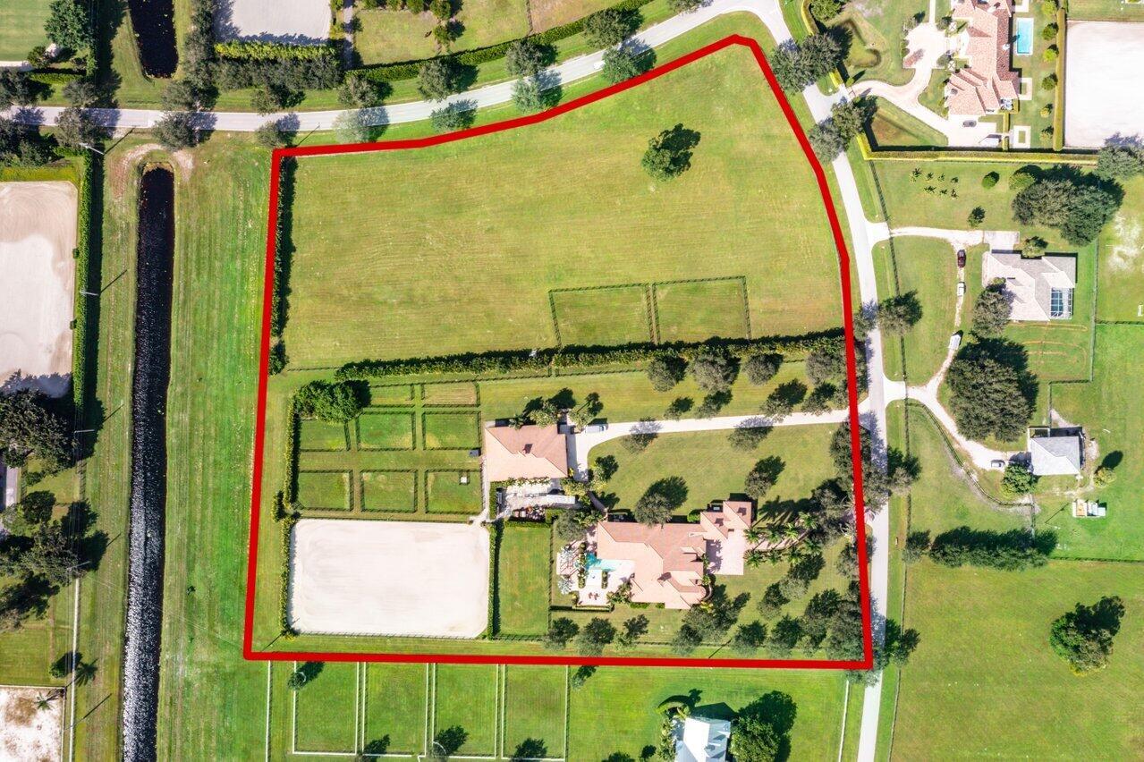 Over 10 Acres in the Exclusive Palm Beach Point community!  Close to all equestrian venues, this custom built home is situated on one of the highest lots in Palm Beach Point. The property features a 9 stall barn with easy conversion for more, tack room, feed room, laundry, a 1 bedroom apartment, large ring and 11 paddocks. The following run both house and barn: 45KW generator, reverse osmosis water system and complete impact glass and doors. The adjoining 5+ acres is perfect to add an additional barn/housing, covered arena, grass field, paddocks, etc.  The main home has it all for the family and entertaining. The home boasts glorious cathedral ceilings, marble floors, Jerusalem stone & teakwood floors.The kitchen has custom wood cabinets w/self-closing drawers, granite counters, vegetable sink, GE Monogram appliances & professional grade gas range. Master offers beautiful onyx countertops, Kohler spa tub w/heater, walk-in shower & gas quick recovery water heater. Features a gym & steam room w/surround sound throughout.  Two additional large bedrooms, each with private full bath. The family room features built-in entertainment center, surround sound and 55" flat screen TV, & gas fireplace. Large heated pool & spa with waterfall - equipped with remote controls. Poolside summer kitchen with GE BBQ and granite counter. There is also an exterior full cabana bath. Attached four car garage provides ample room for all of your vehicles.  Landscaping is impeccable - with a special touch of gorgeous purple and white orchids gracing the trees along the driveway and in the pool and entertainment area as well.
