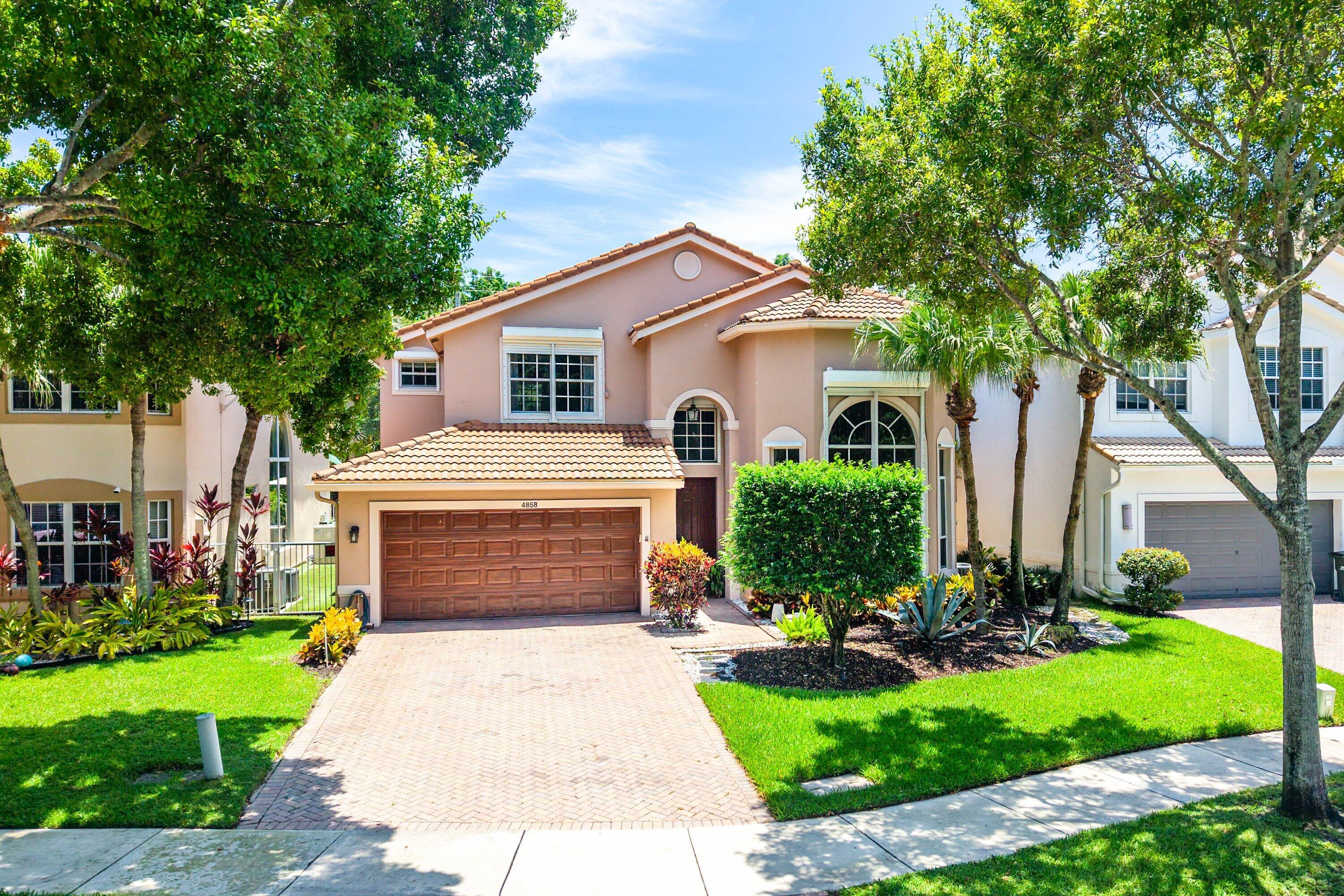 Nestled within the gated community of The Colony at Delray Beach, just approximately 10 minutes from the famed Atlantic Avenue, this spacious and light-filled residence offers an exceptional blend of comfort, privacy, and everyday convenience. Soaring two-story ceilings and expansive windows fill the home with natural light, creating an inviting sense of openness throughout. Designed with both functionality and flexibility in mind, the residence offers approximately 3,000 square feet of living space, featuring a desirable first-floor primary suite, additional guest bedrooms, a loft, three-and-a-half baths, and a two-car garage. The generously sized kitchen overlooks the family room, creating a seamless setting for daily living and entertaining alike. Privately positioned with lush greenery beyond, the screened patio provides a tranquil outdoor retreat with no immediate rear neighbors. Residents of The Colony enjoy a low HOA and access to an impressive collection of amenities, including a gated entrance, resort-style pool, fitness center, basketball court, playground, and community events throughout the year.